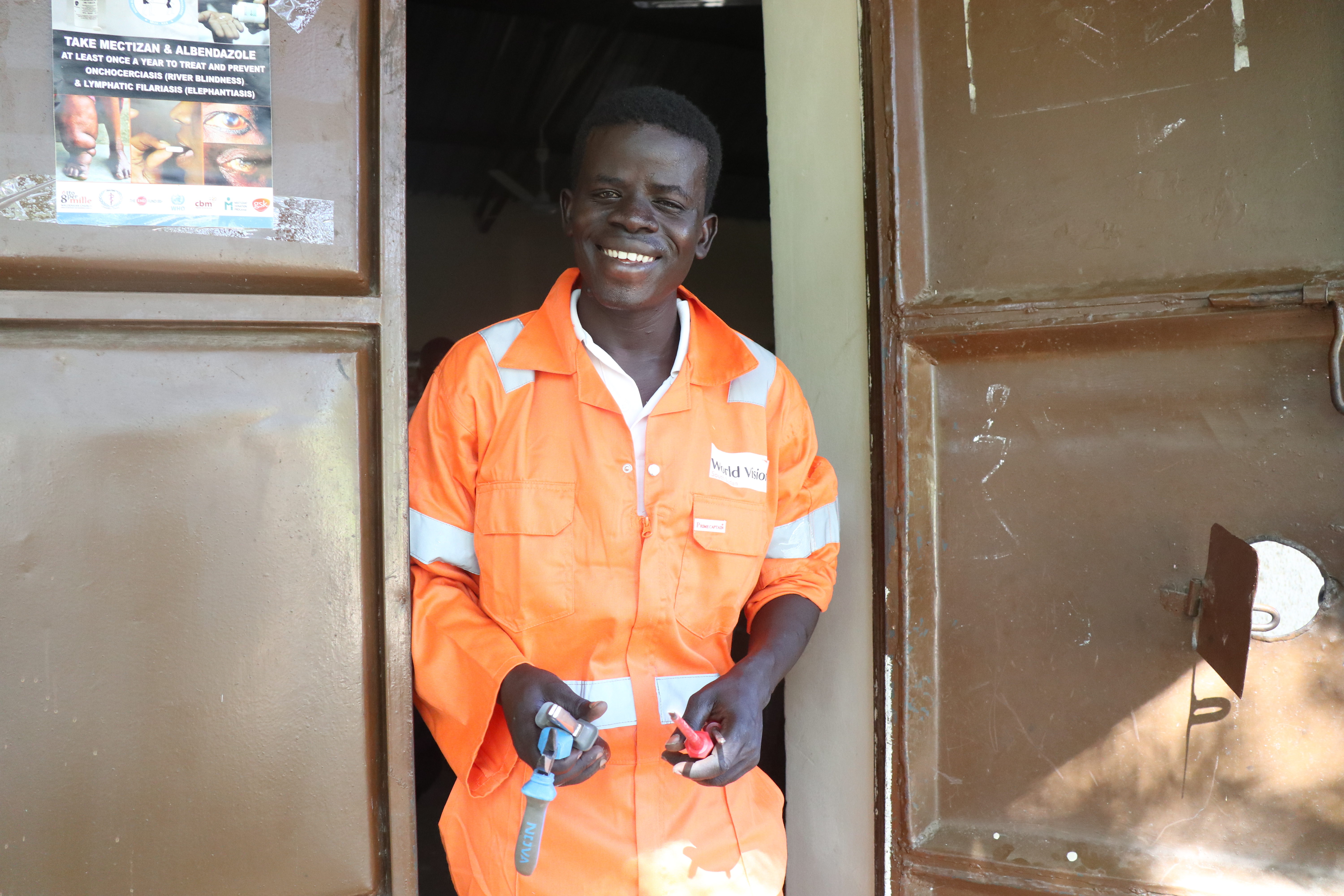Man in orange overalls smiling at camera
