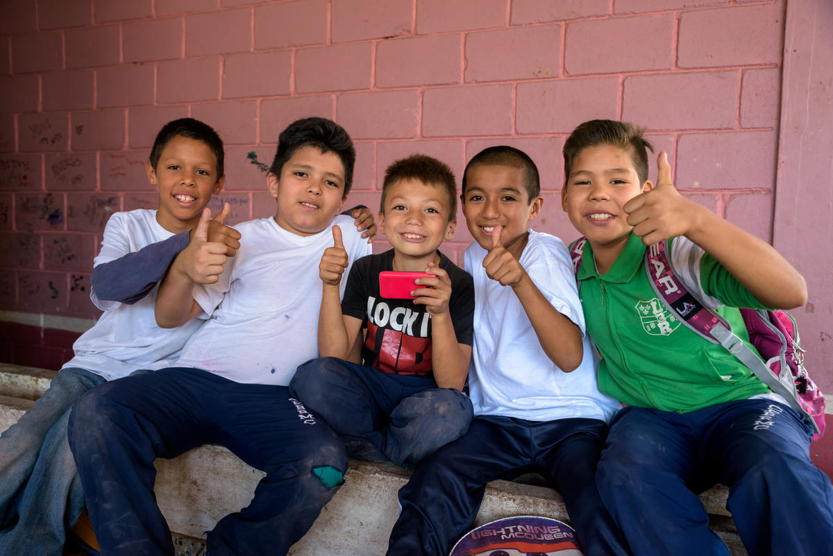 School boys show thumbs up 