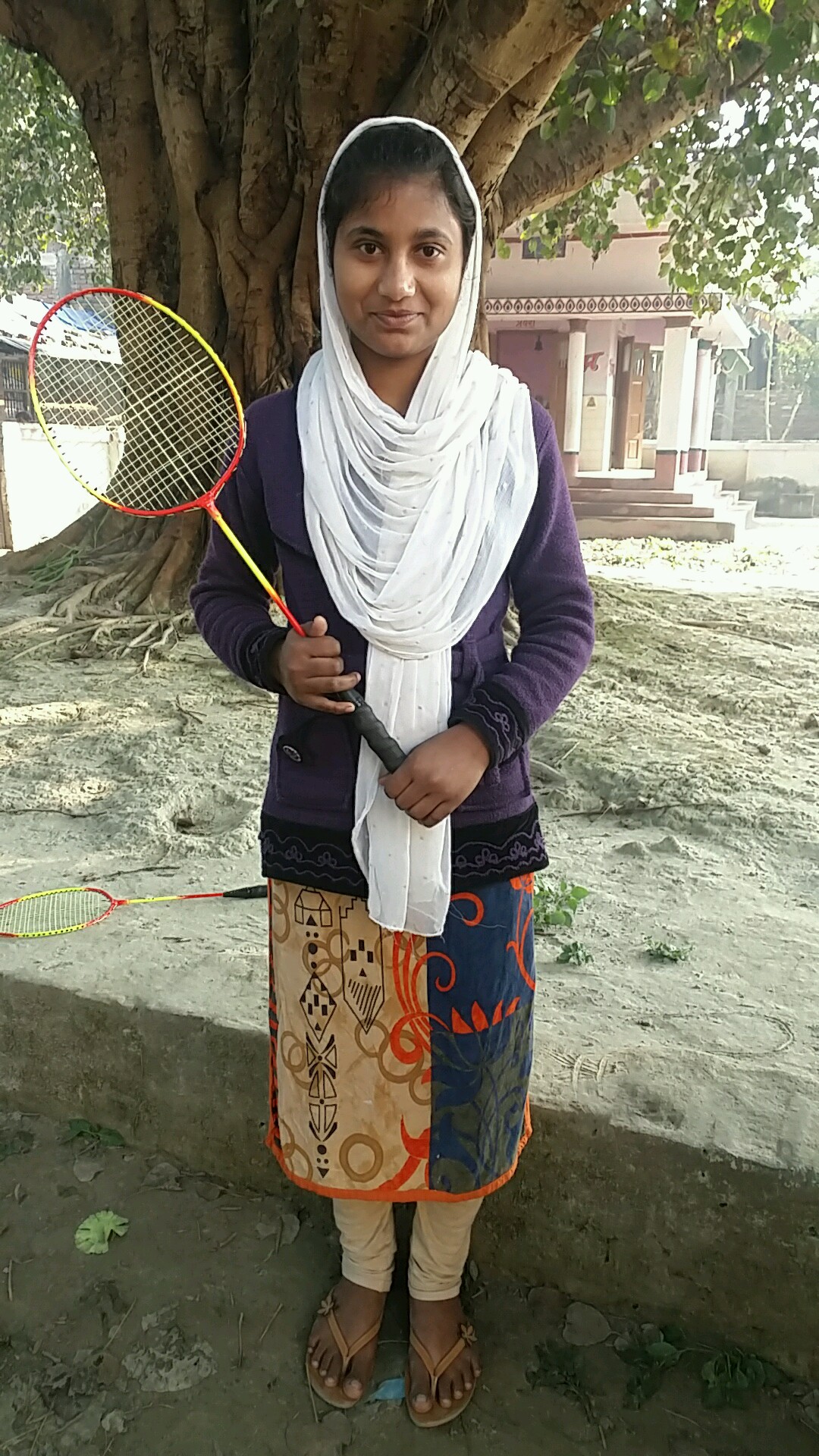 Sama, in India, holds her badminton racket