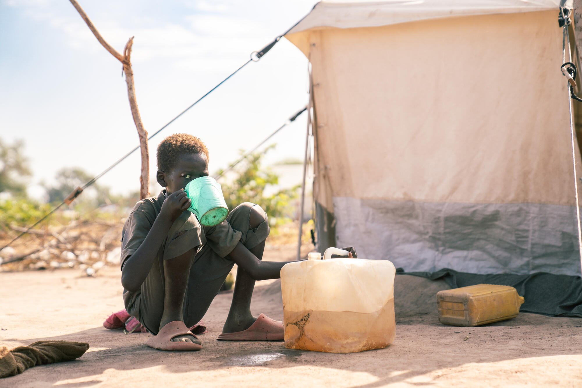 A child sits in front of tent at Wedweill Refugee Settlement in South Sudan