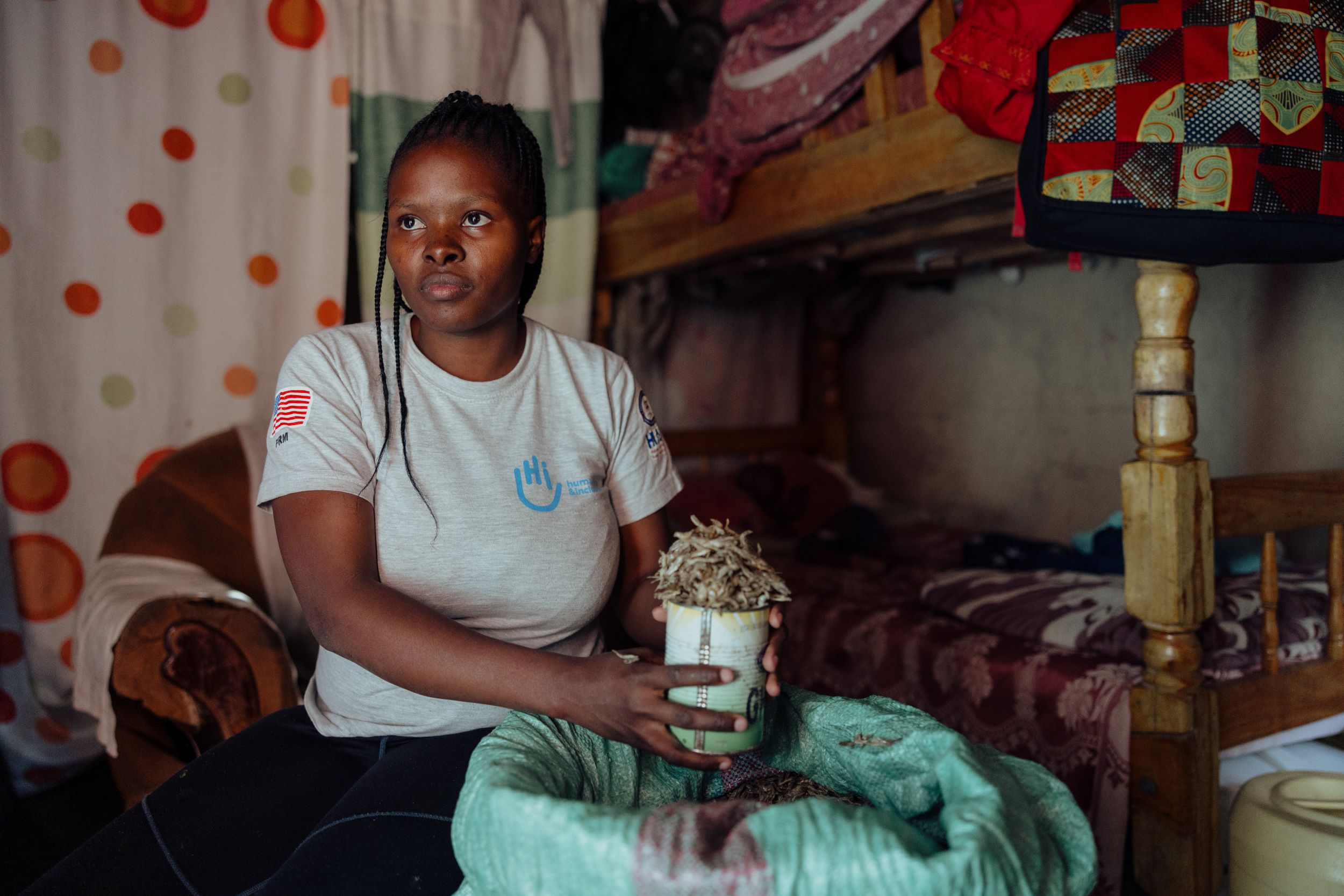Kenyan woman poses with produce from her home run business
