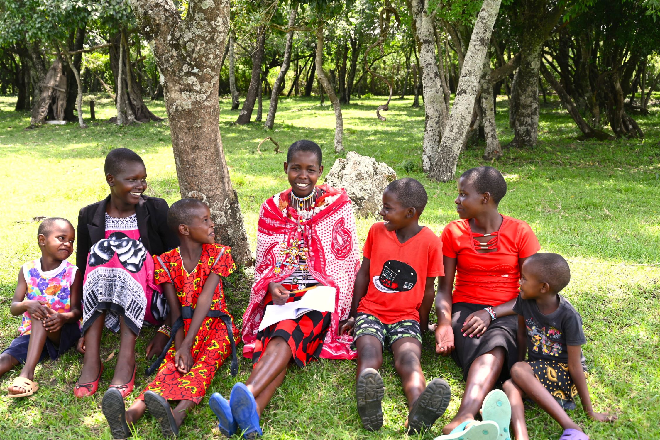 Kenyan children sitting under a tree