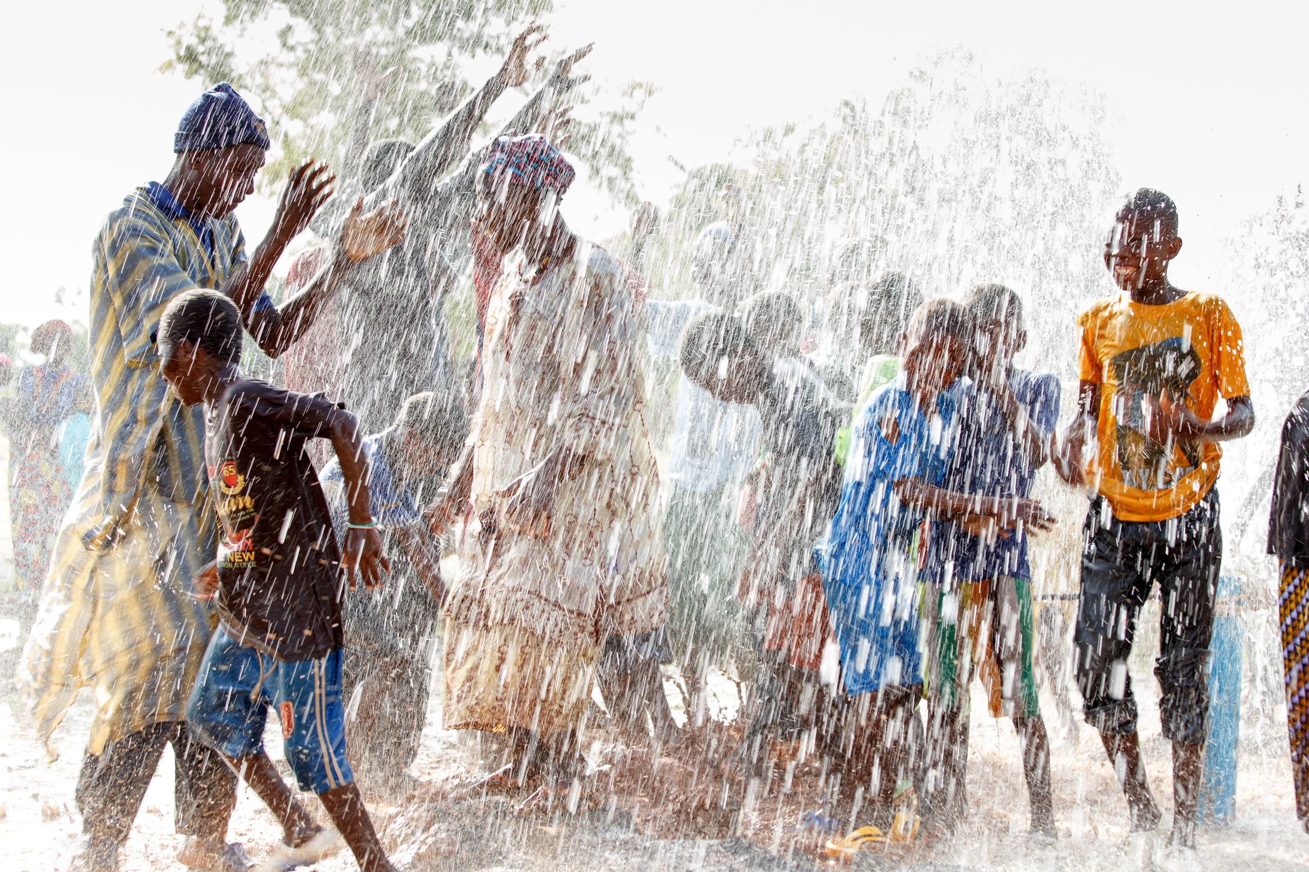 A community in Mali celebrate in the gushing water from their new borehole 