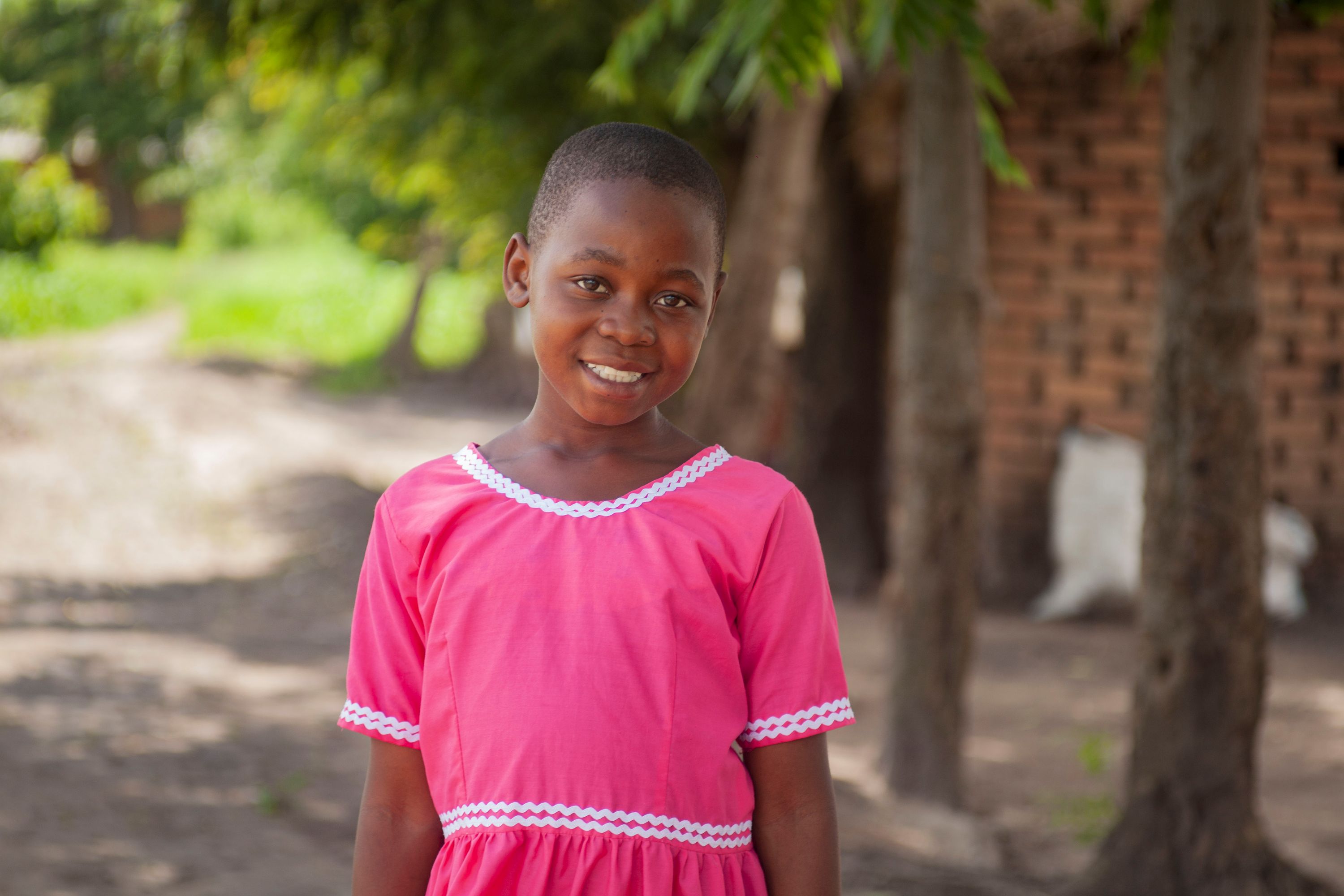 No more stomach pains for Flora, 11, pictured smiling in a bright pink dress