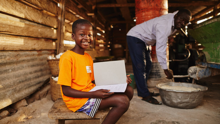 Akuamoah smiles as he reads at home