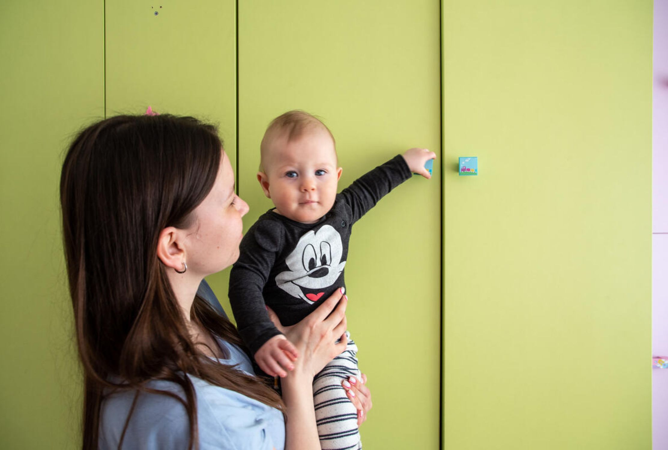 Ukrainian mother holding 10-month-old son, looking at the camera
