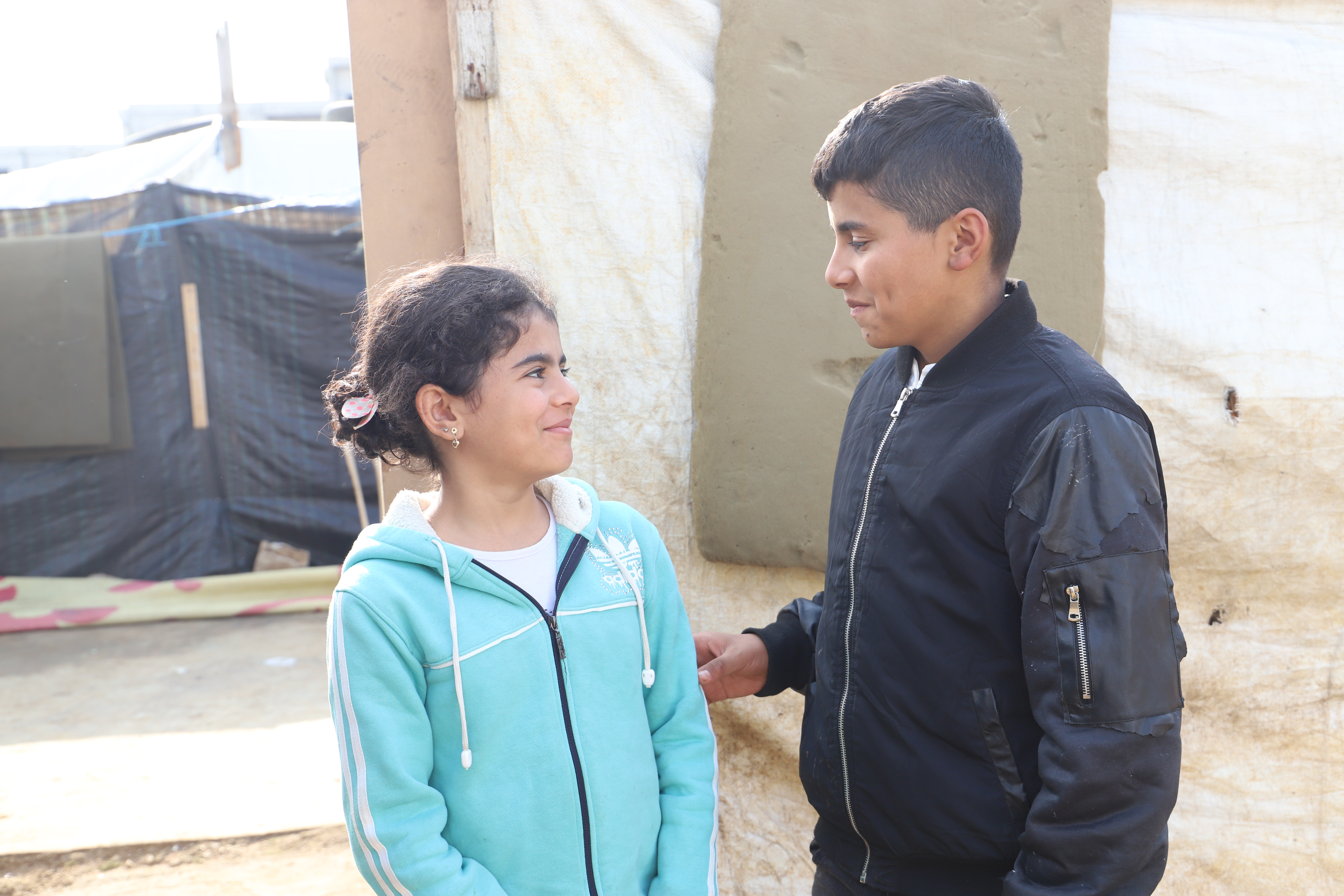 Two Syrian children, boy and girl, talking at a refugee camp in Lebanon