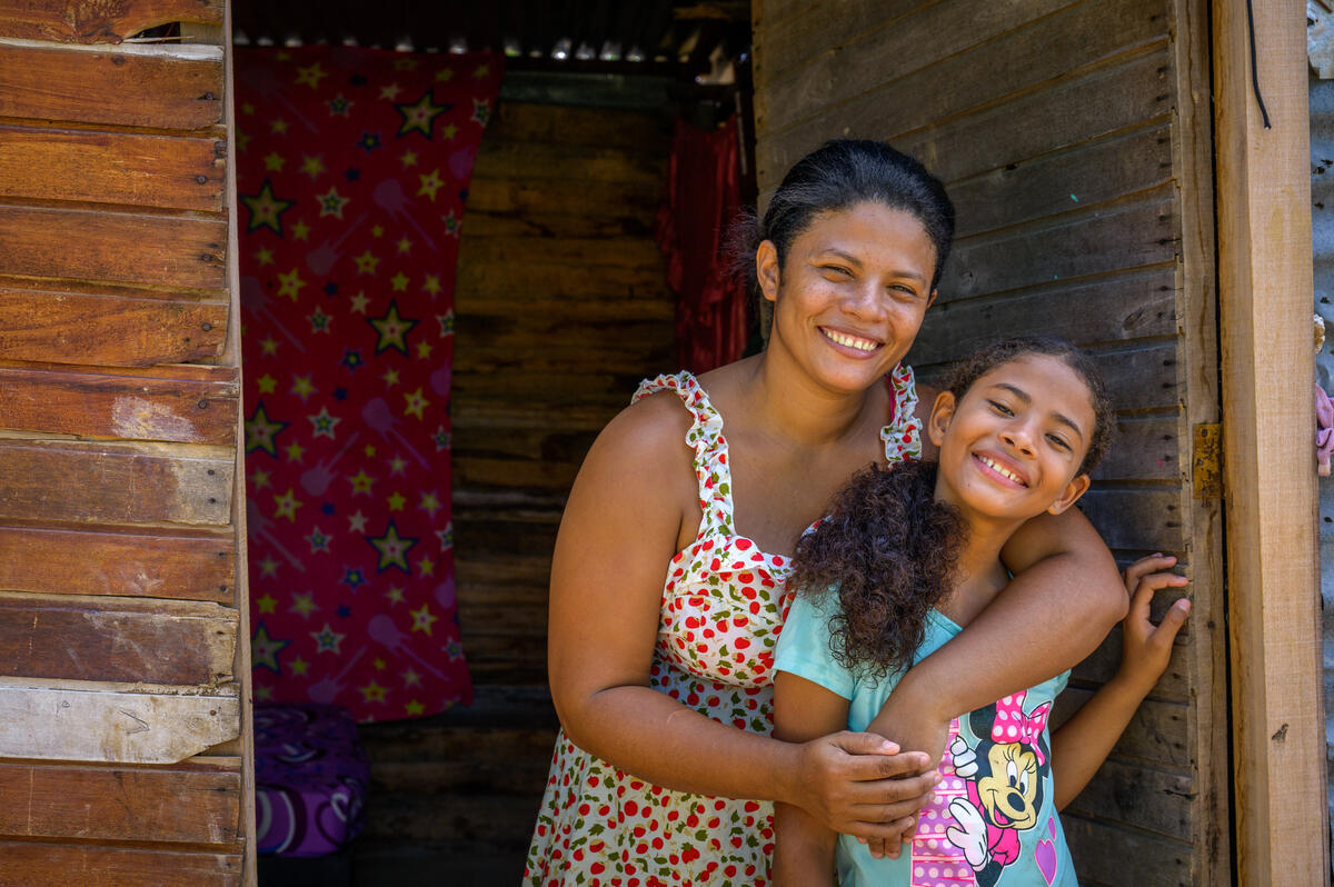 Mariangel hugs her 9-year-old daughter in the doorway of the family’s home.