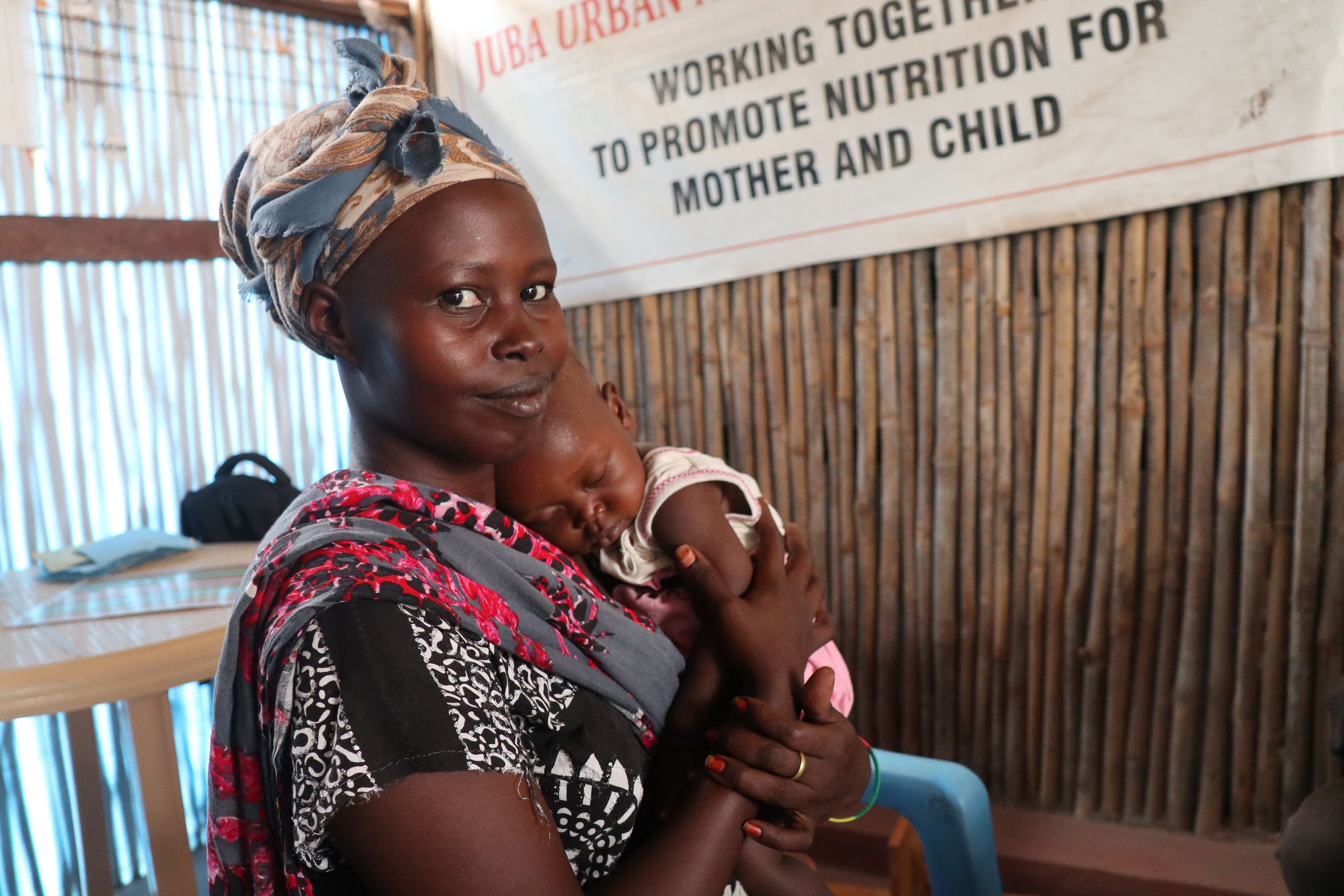 In South Sudan, mother Hanan Mahamud, 27, takes part in a nutrition session with her baby.
