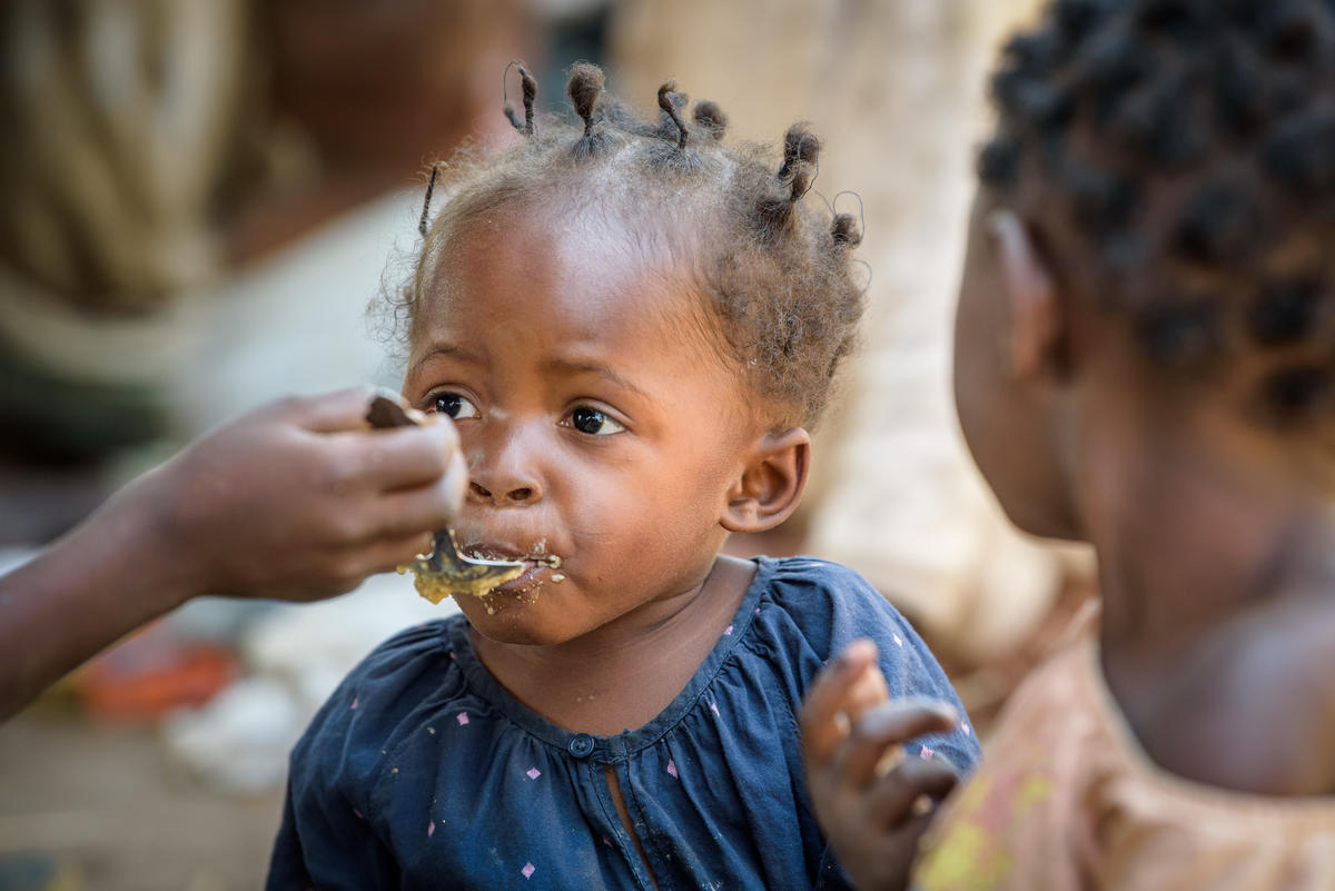 Young toddler is fed with a spoon