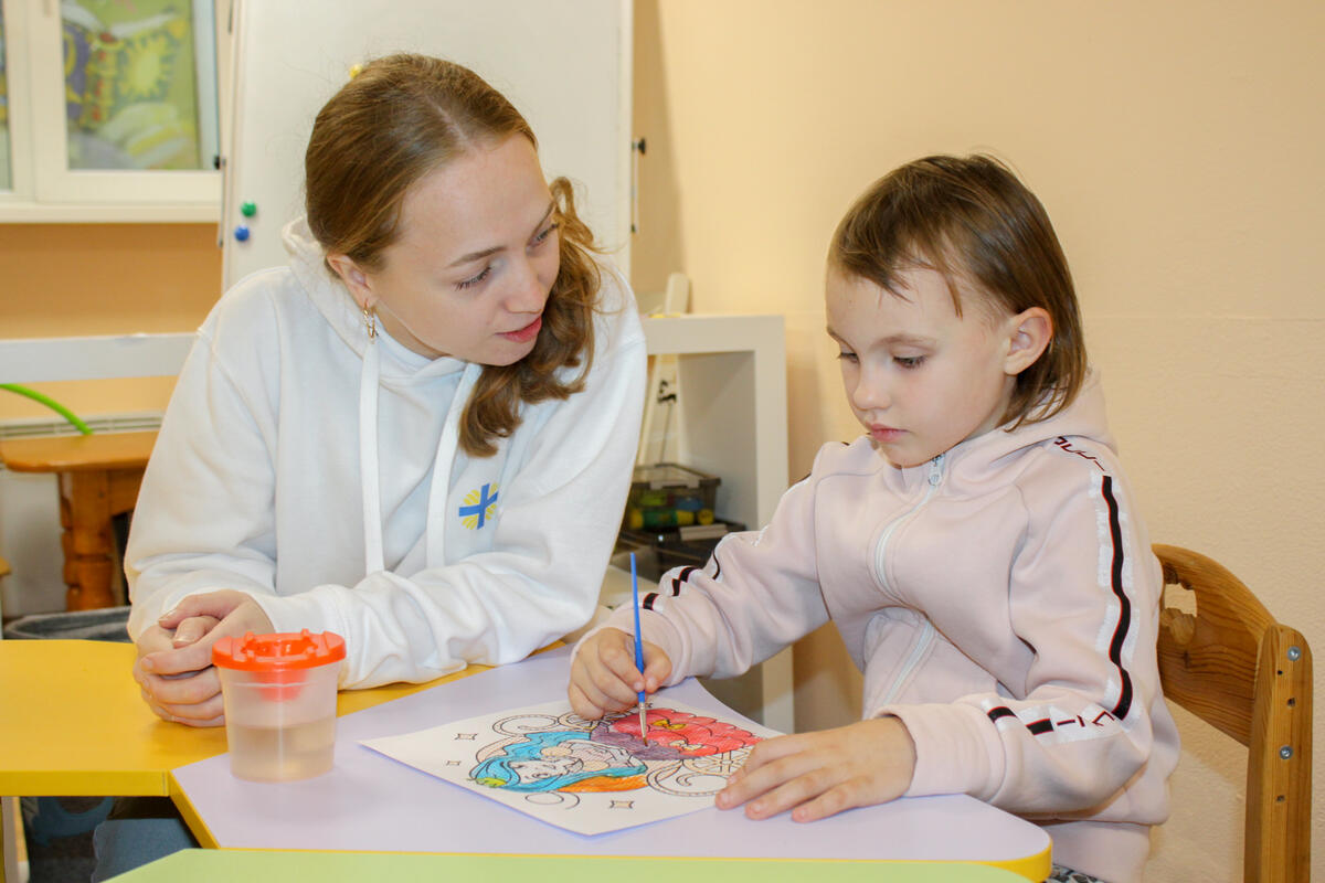 Mother and daughter from Ukraine doing artwork at a table