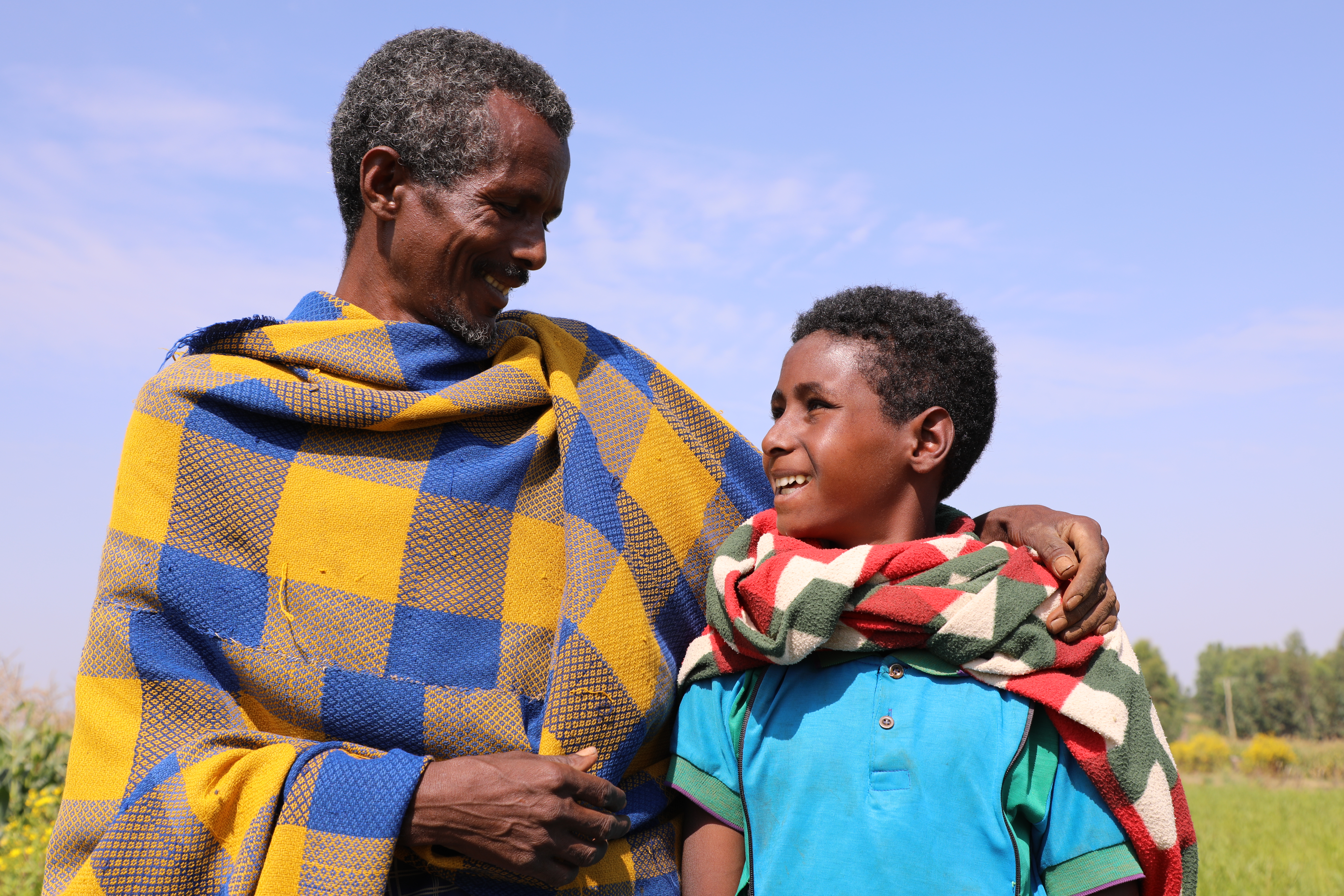 Yibeltal's father stands with Yibeltal, with his arm around his son's shoulders