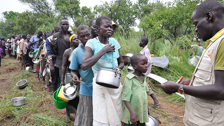 Families wait in a queue for food