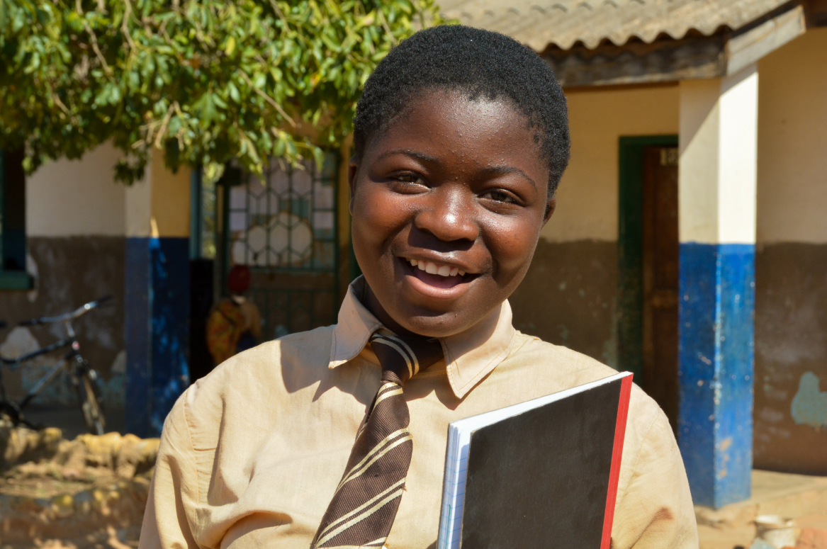 Mary wears her school uniform with pride and smiles