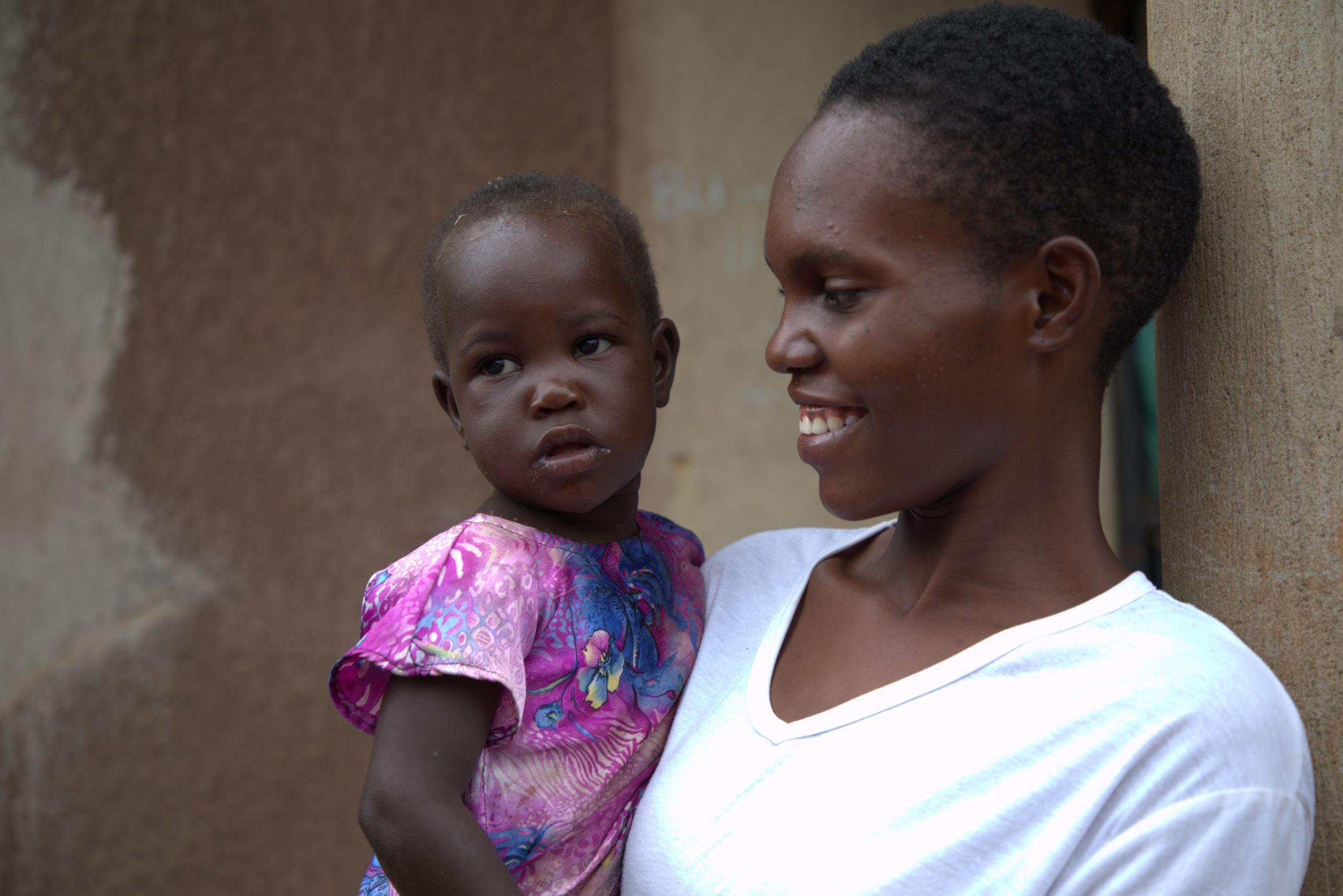Teen Ugandan girl holding her baby girl