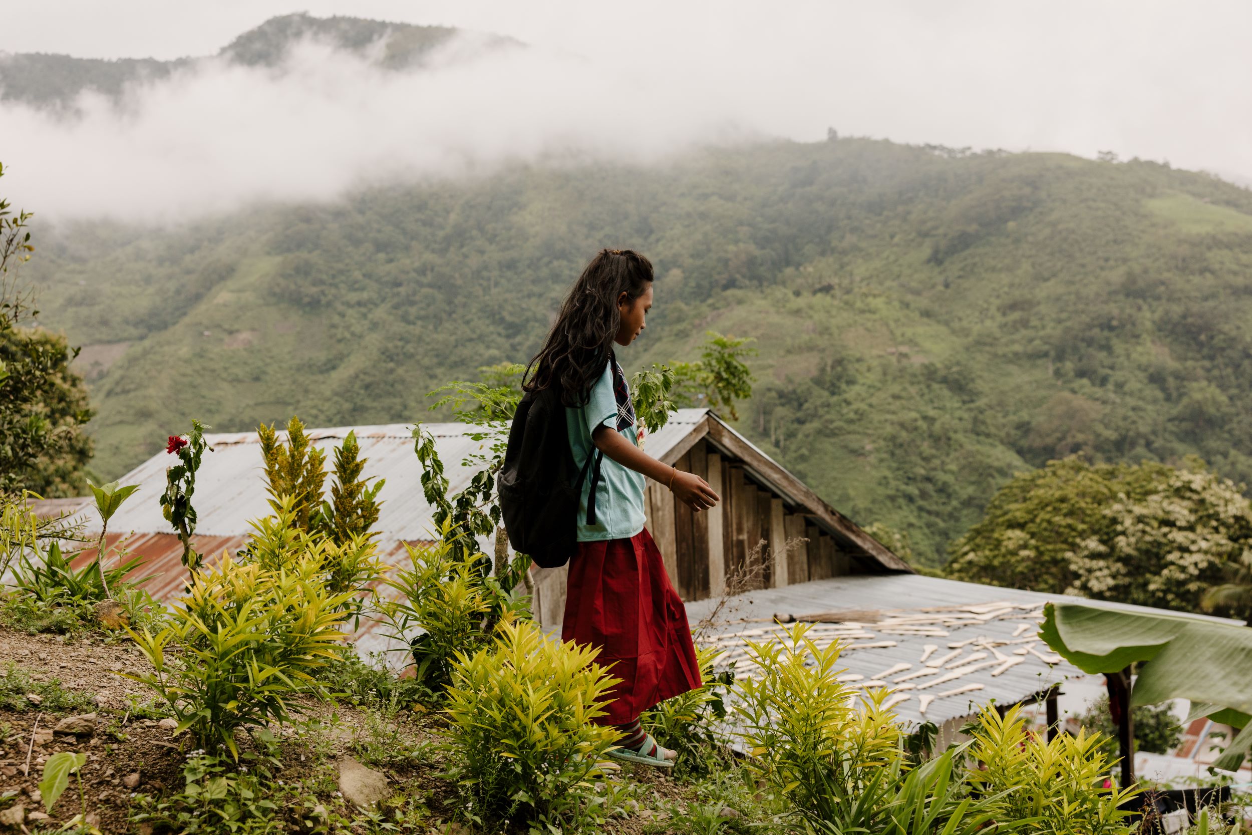 Indonesian girl overlooking buildings in her remote community