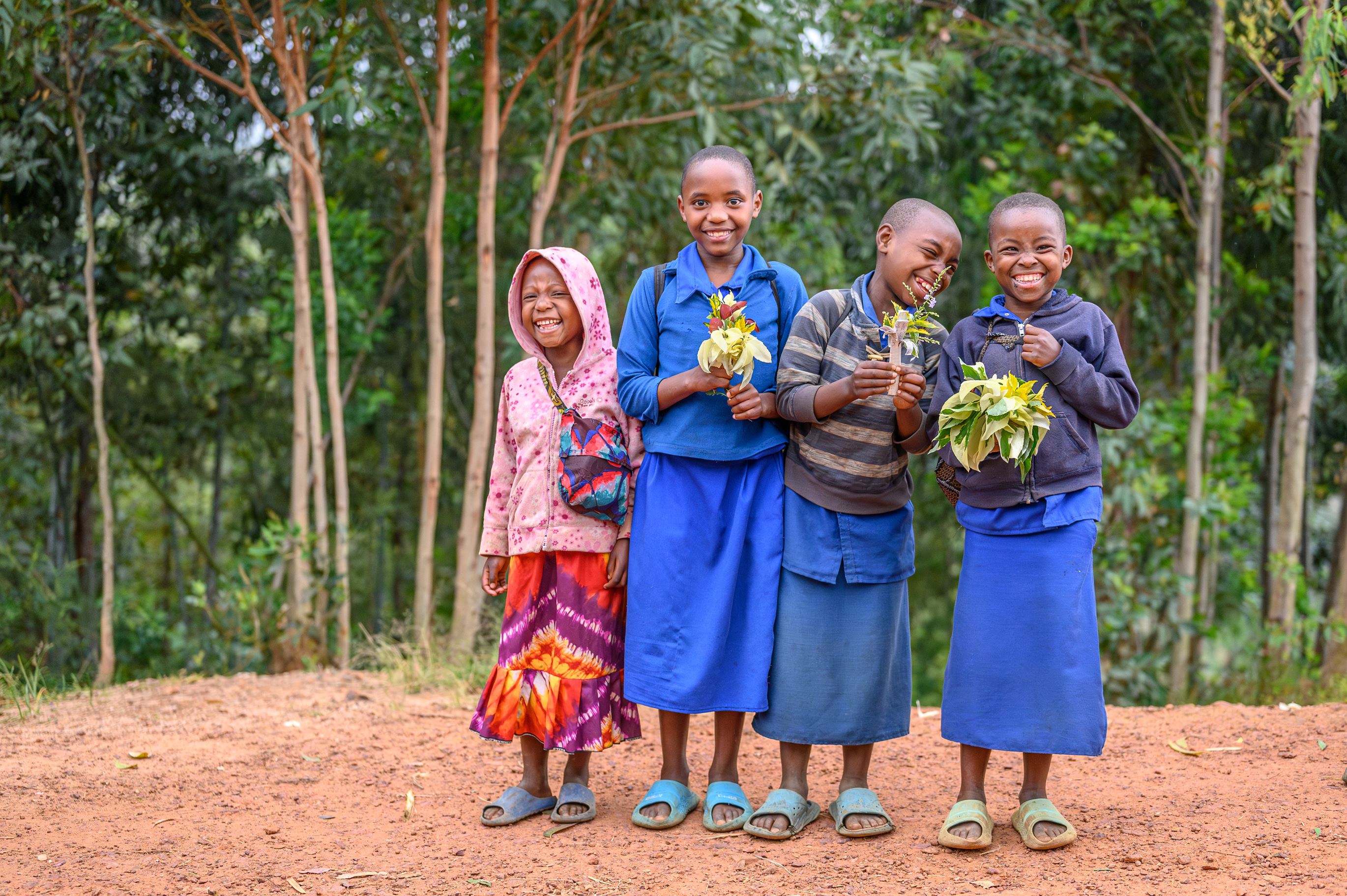Smiling girls in Rwanda with the flowers they took to school on Valentines Day.