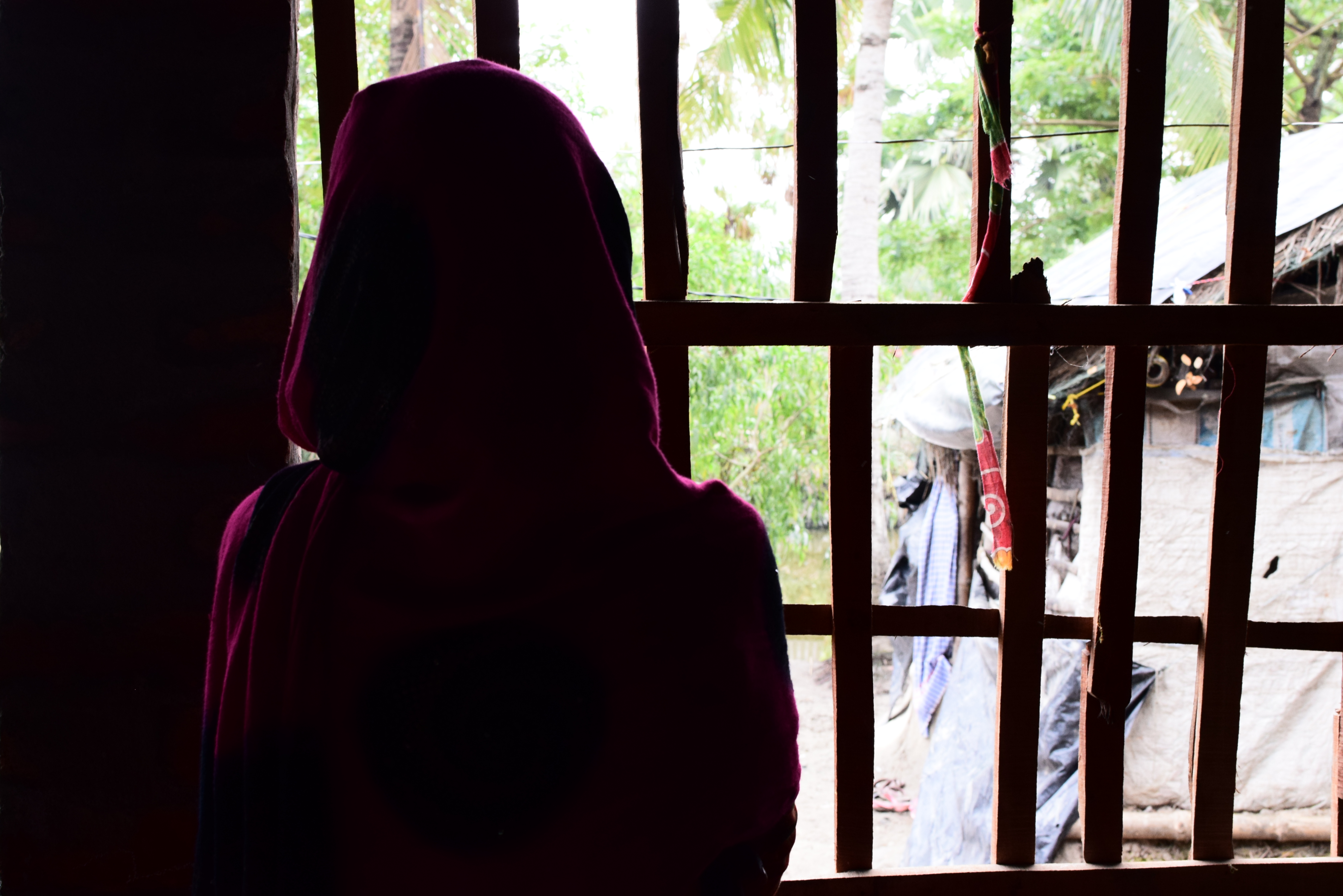 Girl in India looks away from the camera to the outdoor window
