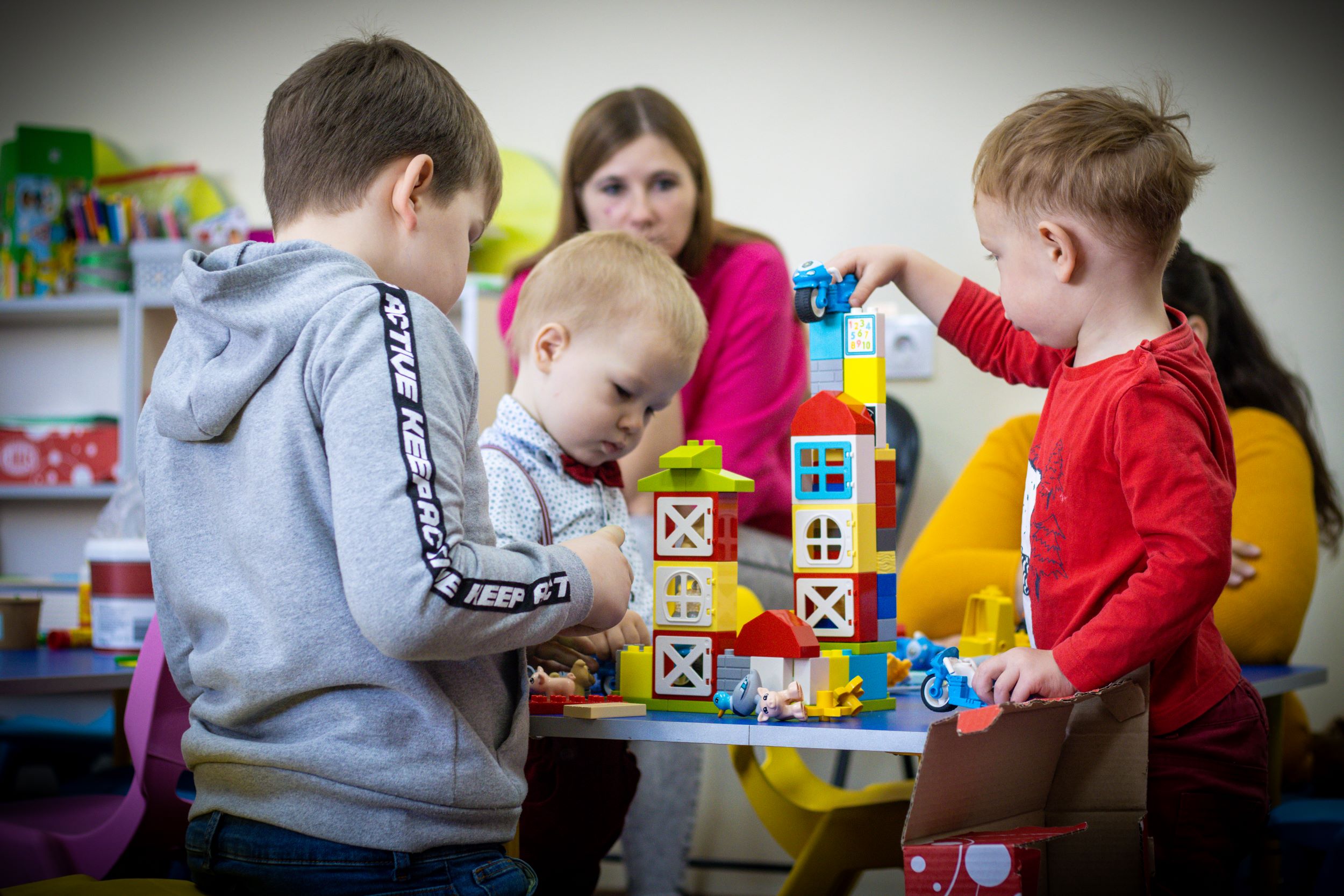 Ukrainian boys playing with colourful stacking toys at a Child-friendly space for children 