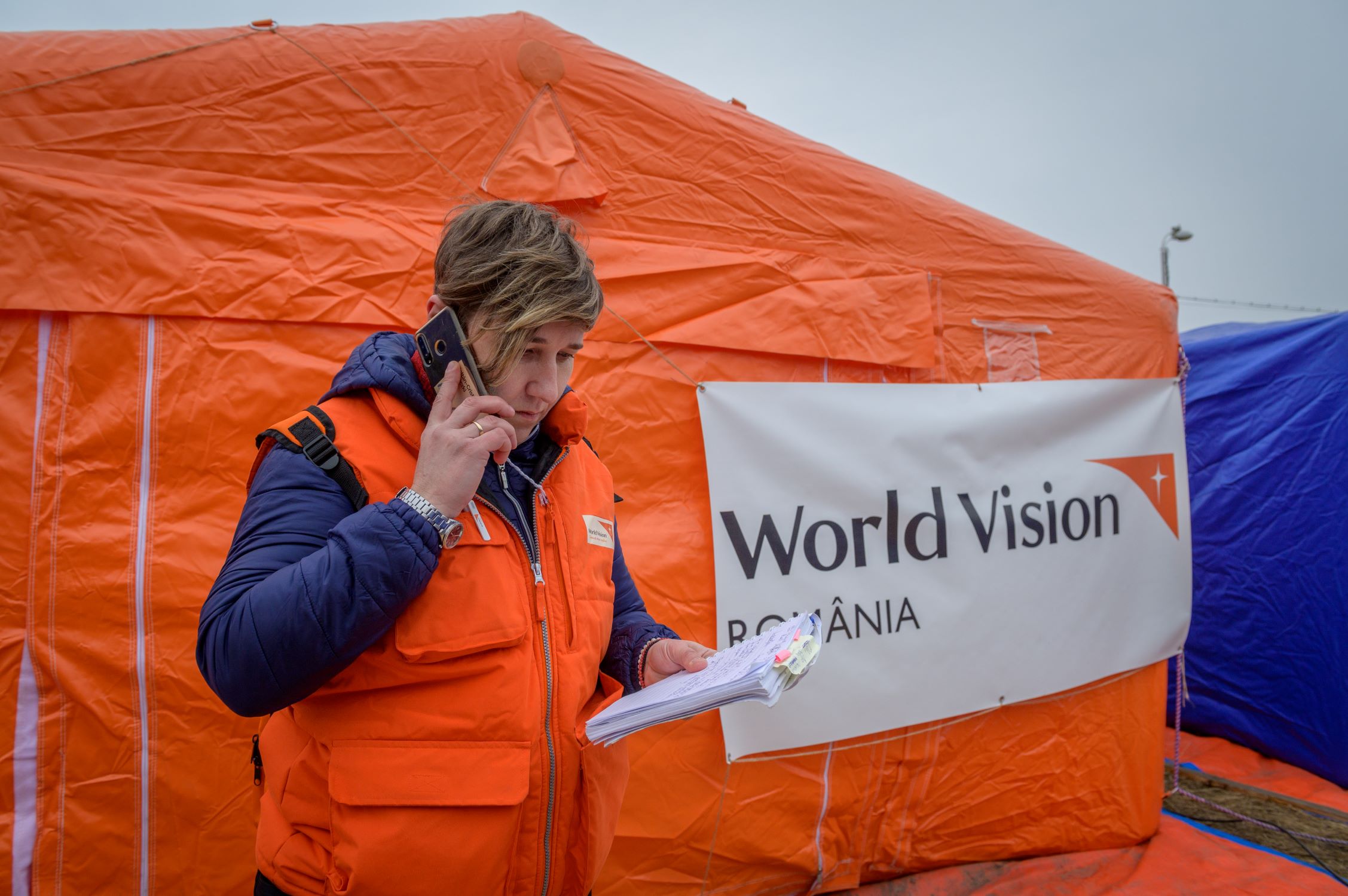 World Vision psychologist Florentina Cretu standing in front of World Vision tent in Ukrainian refugee centre in Romania