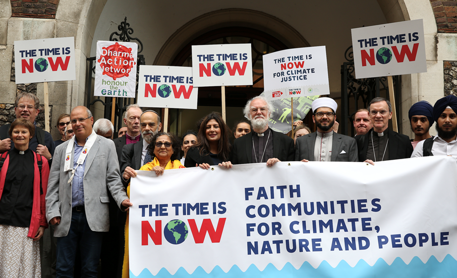 A group of people hold placards and banners to demonstrate at the G7 conference