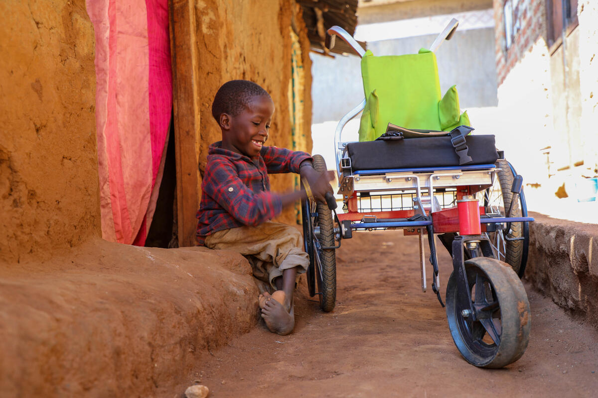 Young boy from Uganda, born with a lower-limb disability received a wheelchair from World Vision