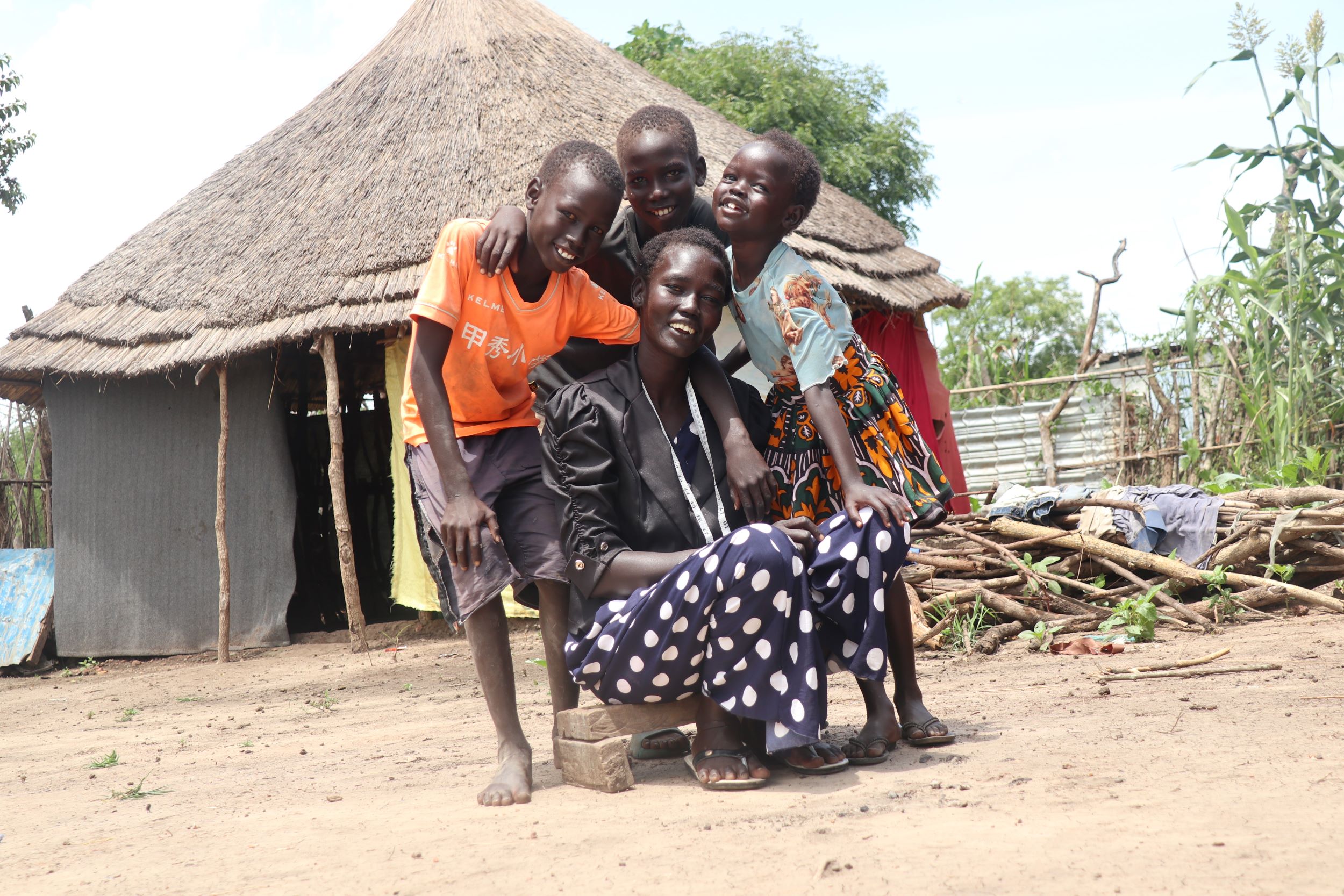 A mother smiles, sitting with three of her children