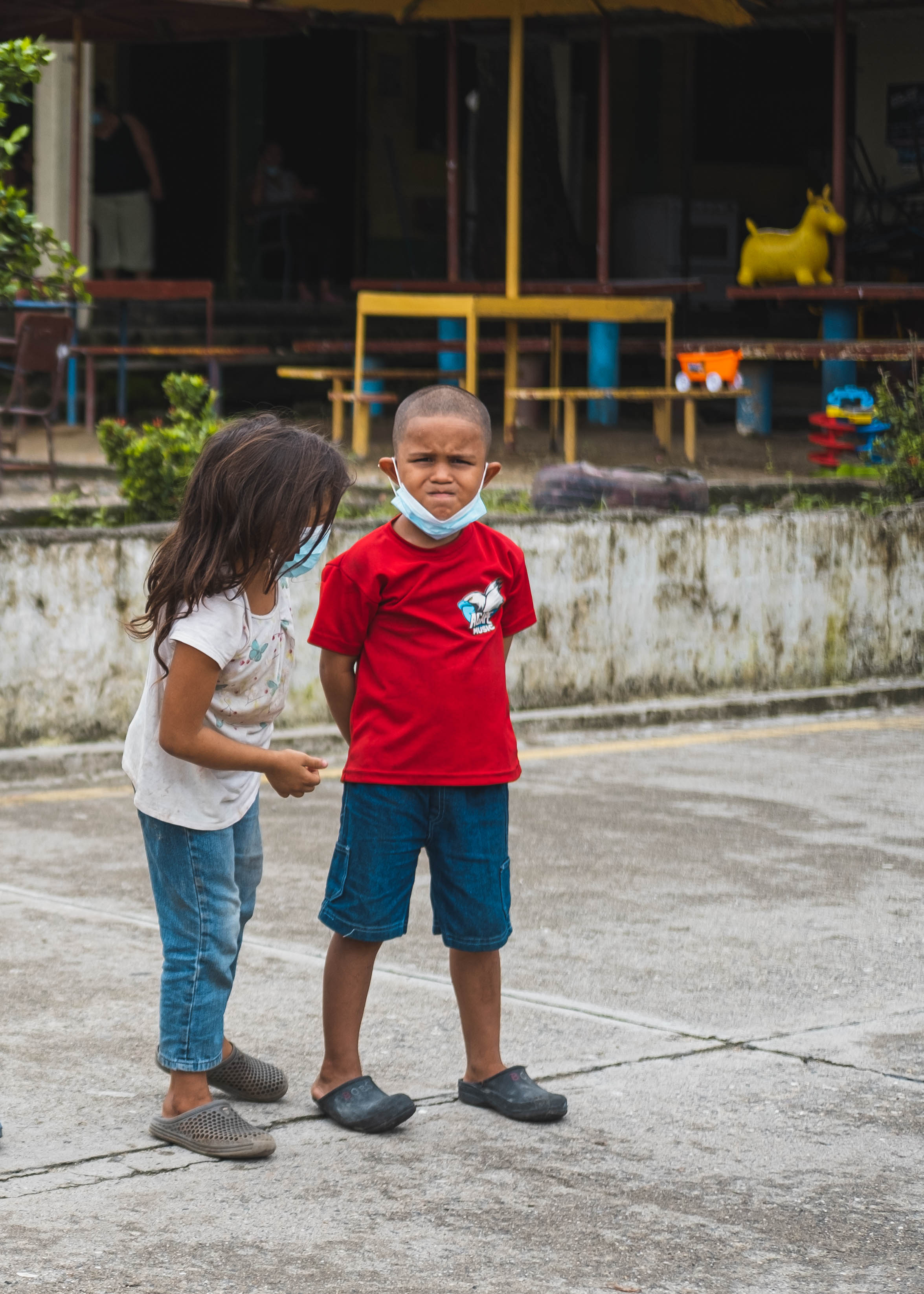 Omar and his older sister taking part in an outdoor activity at a child friendly space.