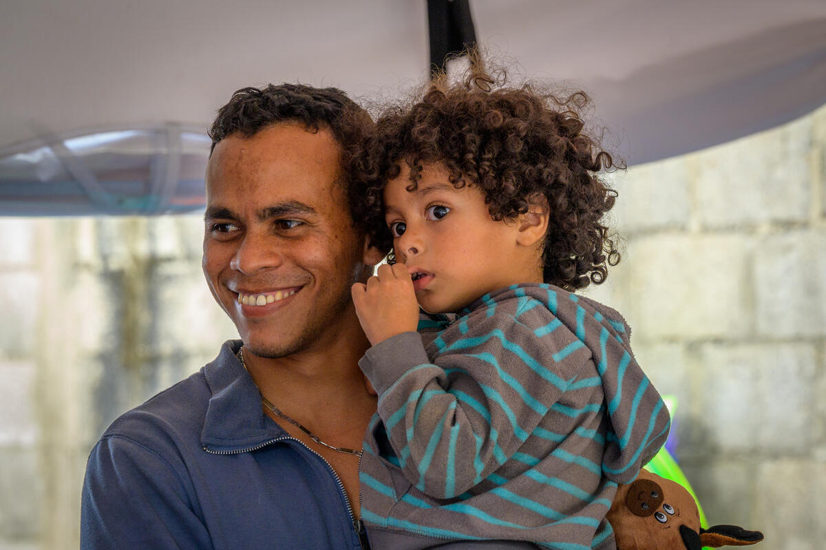 Venezuelan father holding his child and smiling