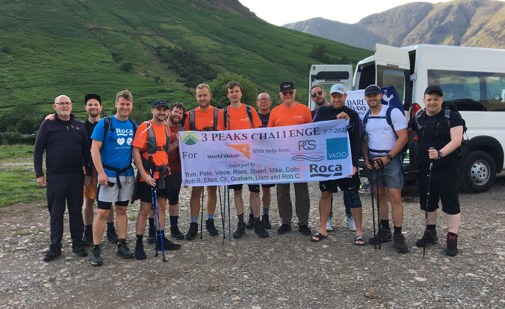 Staff from Premier Contract Supplies stand at the bottom of some hills, after completing the 3 peaks challenge for World Vision