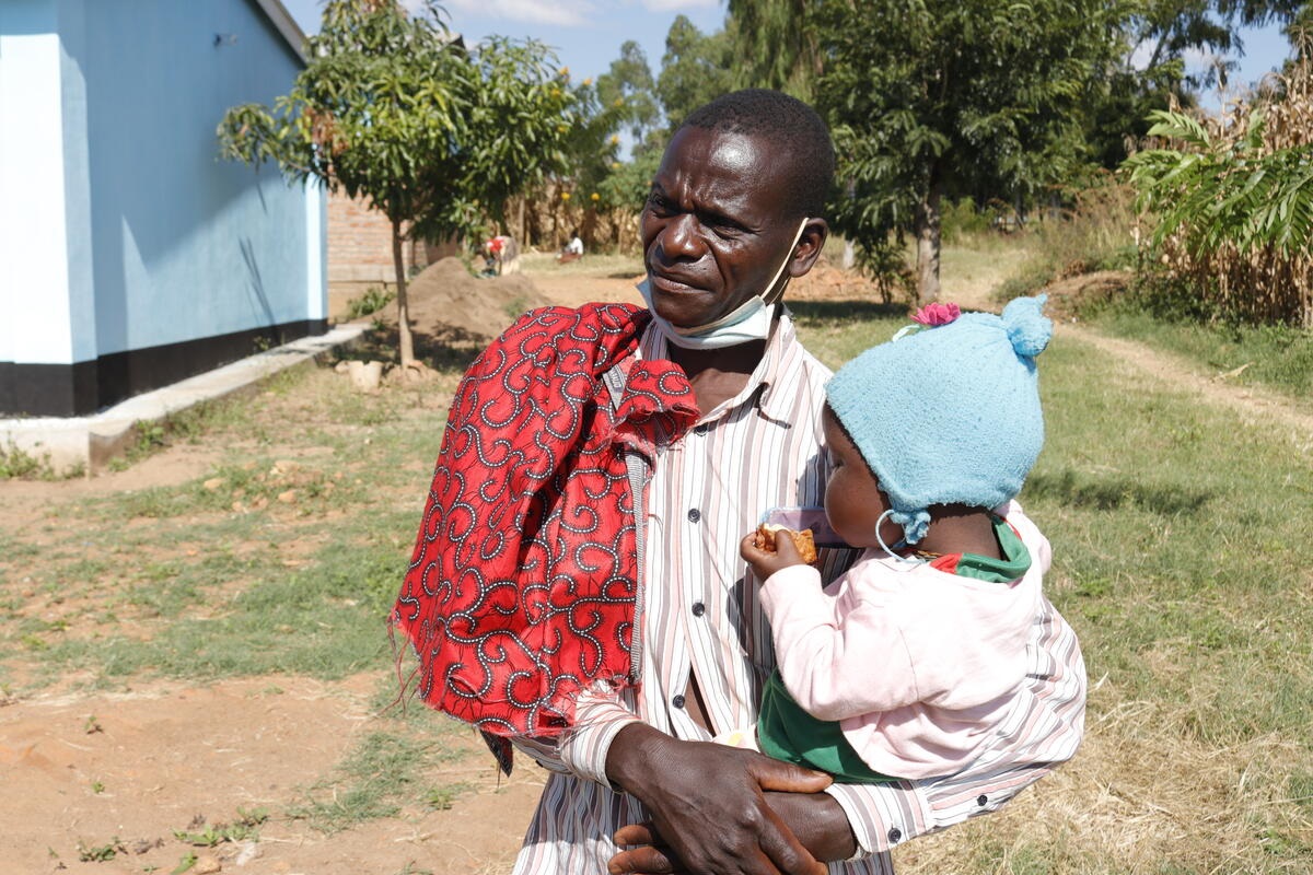 Moses with baby Andrea outside the health centre