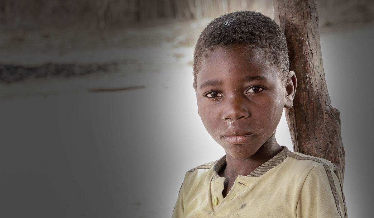 Mid crop of boy in yellow t-shirt looking to the camera without smiling 