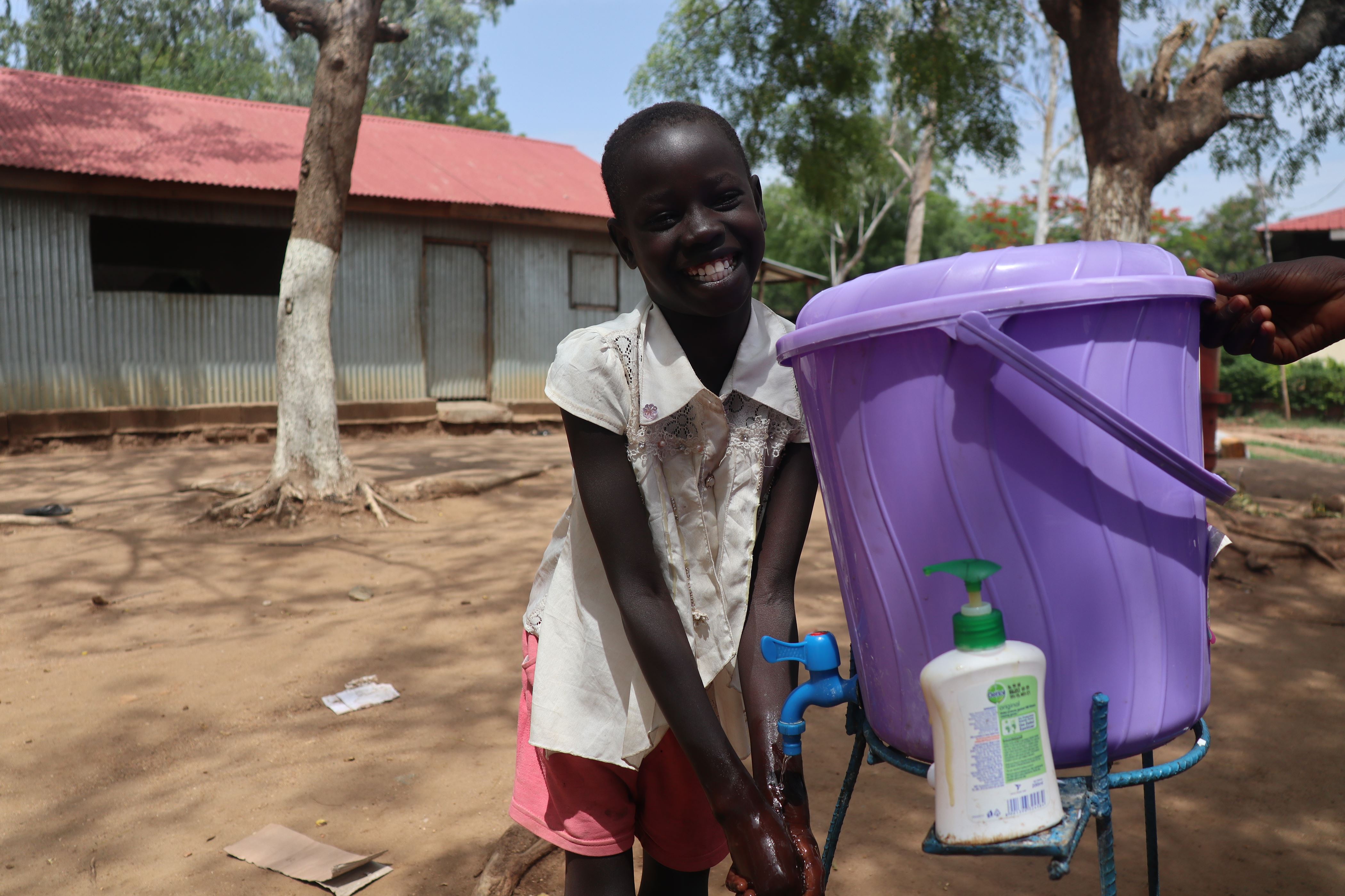 Girl in South Sudan washes her hands