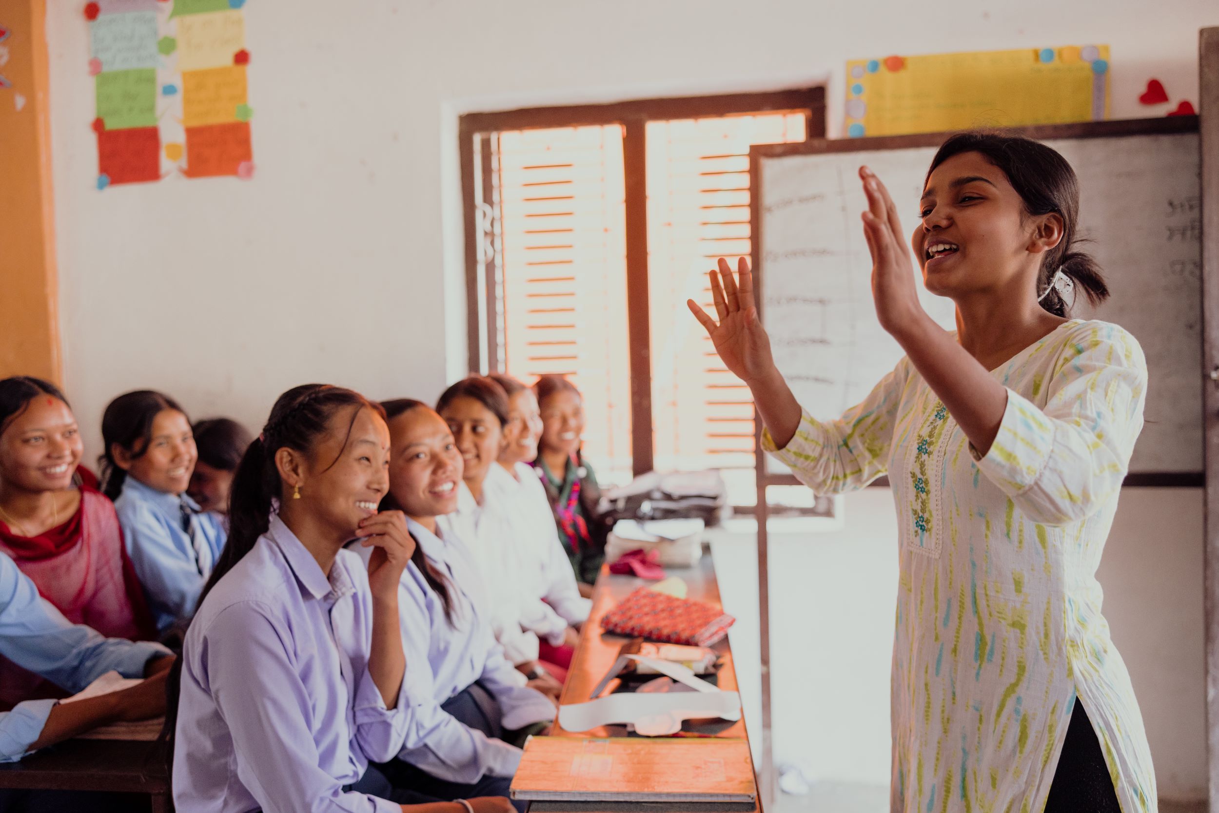 Nepali girl teaching younger students to make reusable sanitary towels