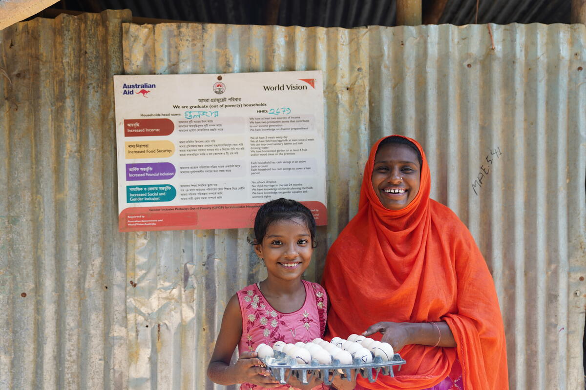 Little girl and mother from Bangladesh holding a tray of eggs