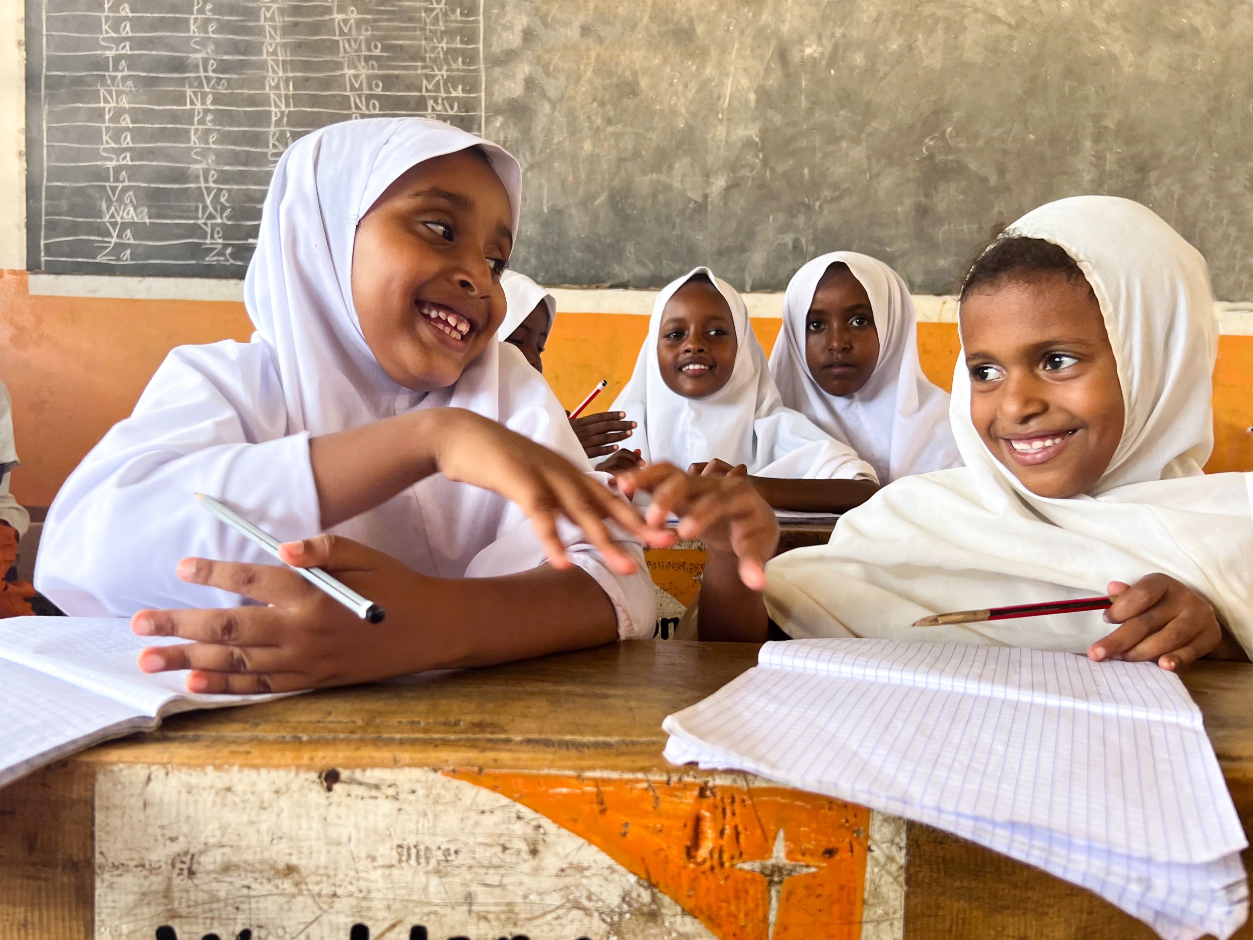 Smiling Kenyan girls in their classroom constructed with support from World Vision