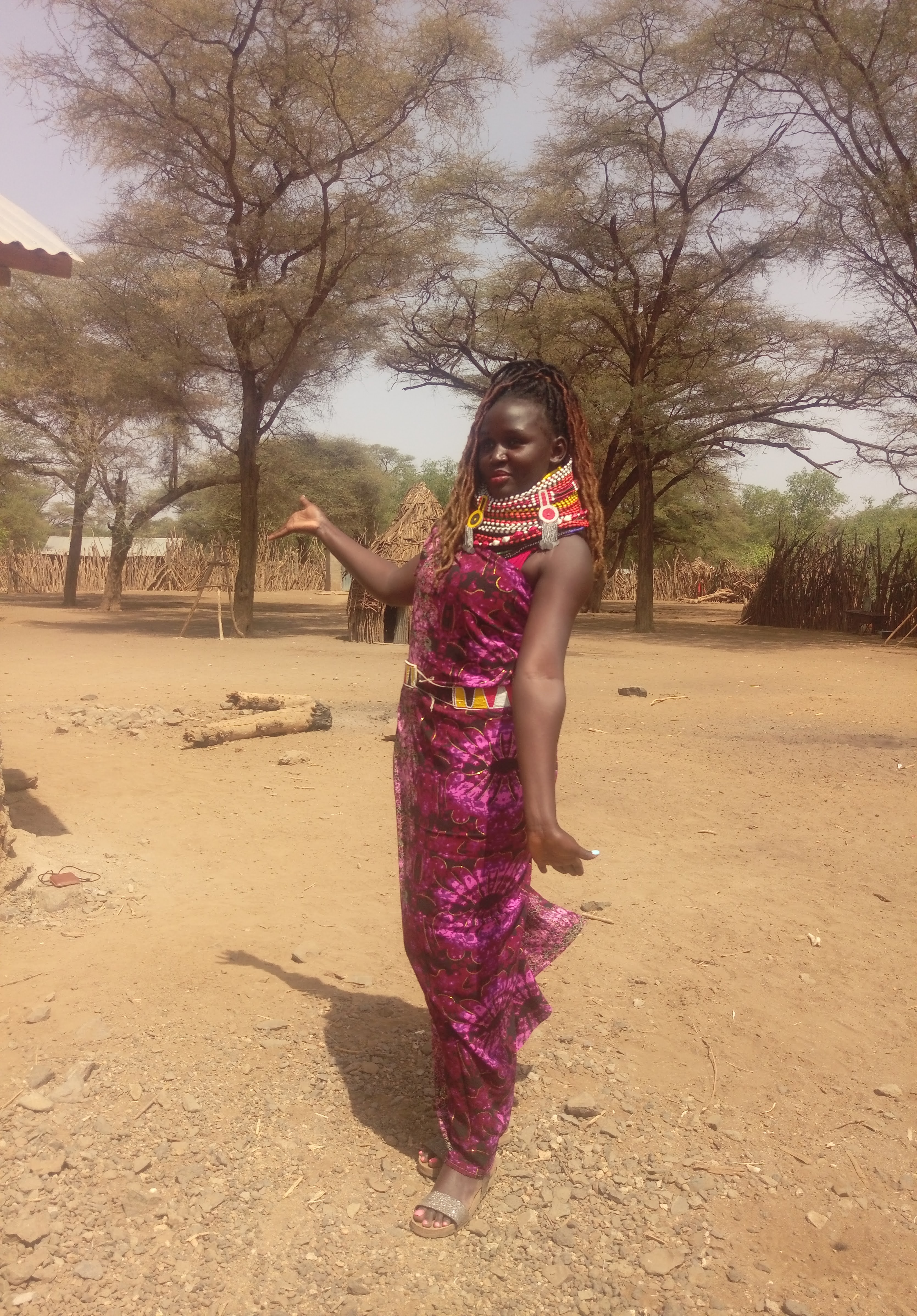 Pauline, in Turkana clothes and jewellery, with acacia trees in the background