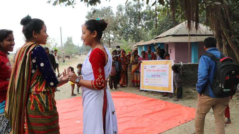 Saru and a friend in traditional saris take part in an open-air drama about child protection