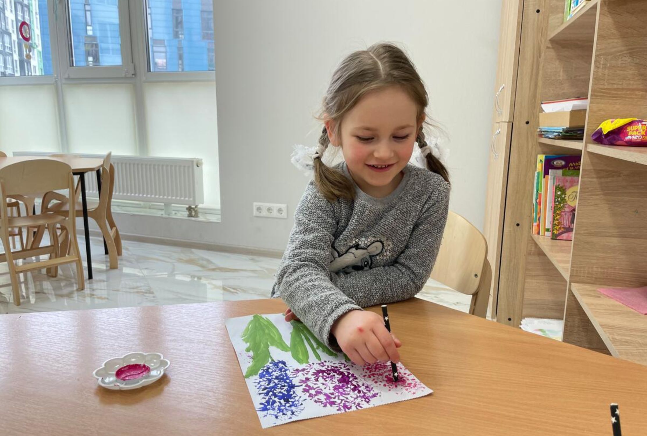 Ukrainian young girl painting at a table