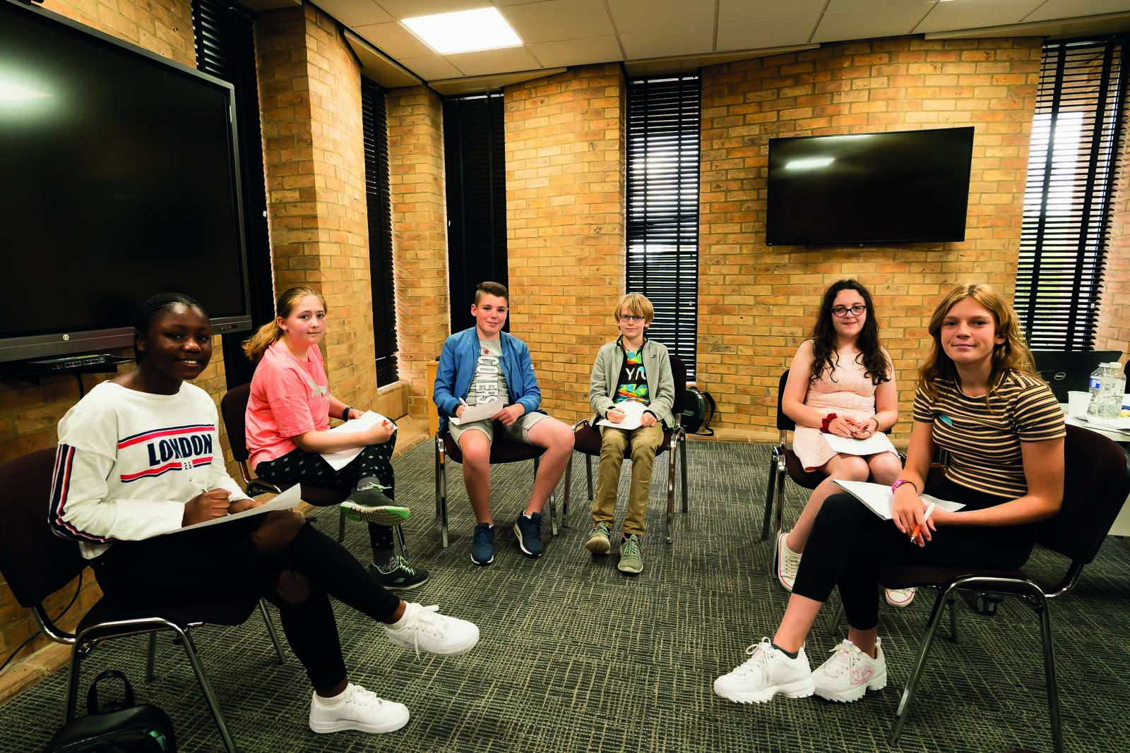 A UK youth cabinet sit and smile to the camera