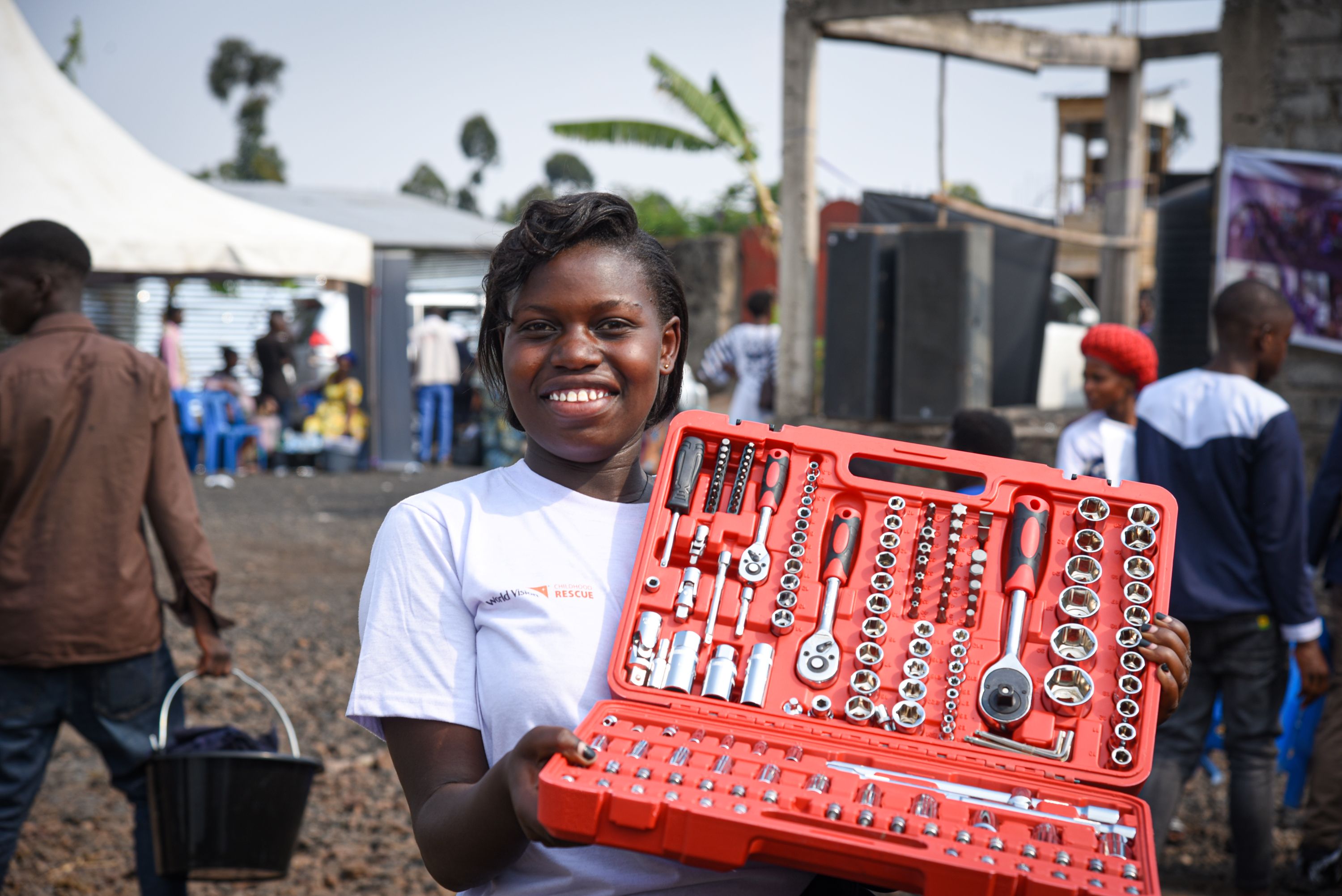 18-year-old Immaculée in DRC holds out the tool set she received upon completing her mechanics training