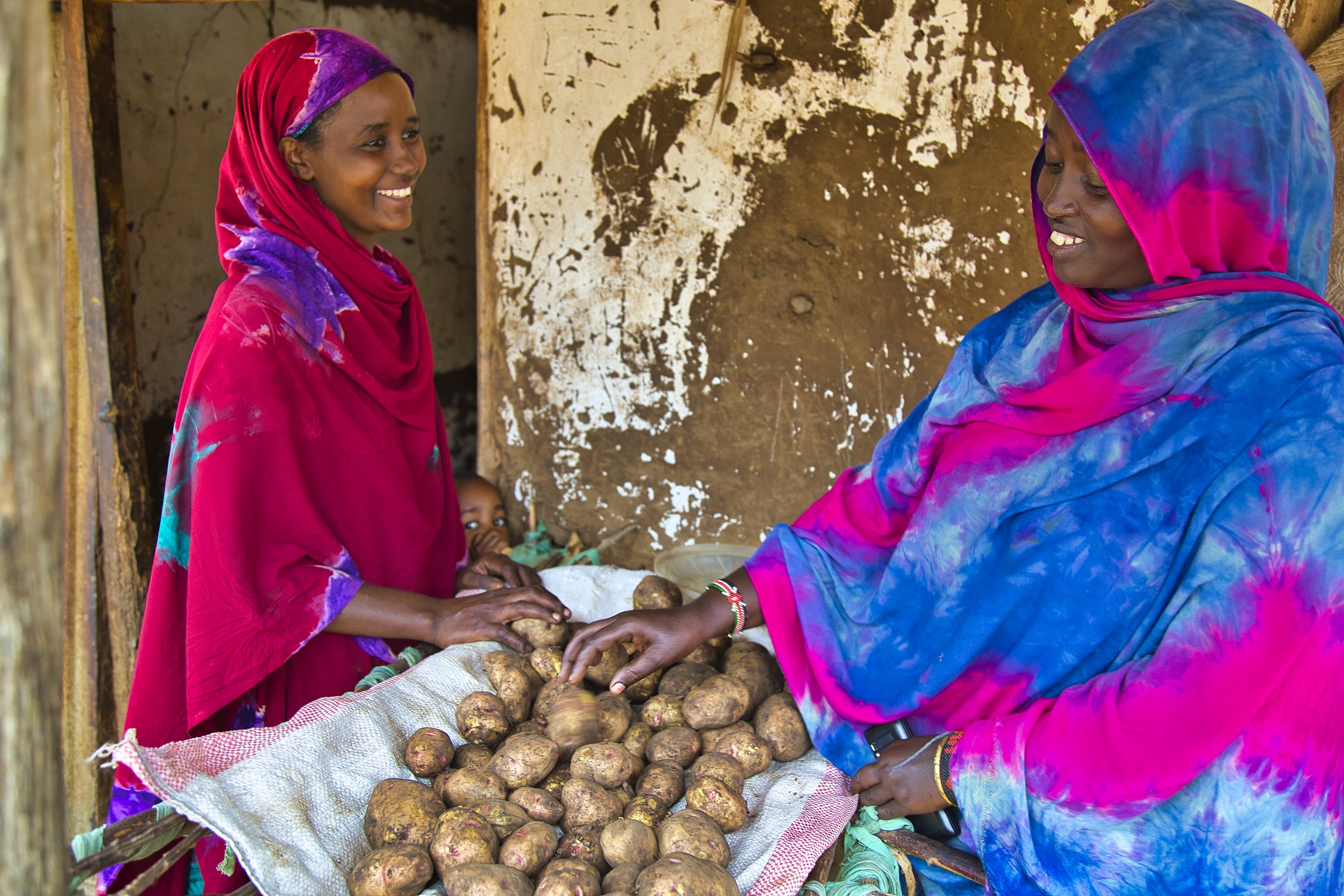 Amina selling potatoes to a customer