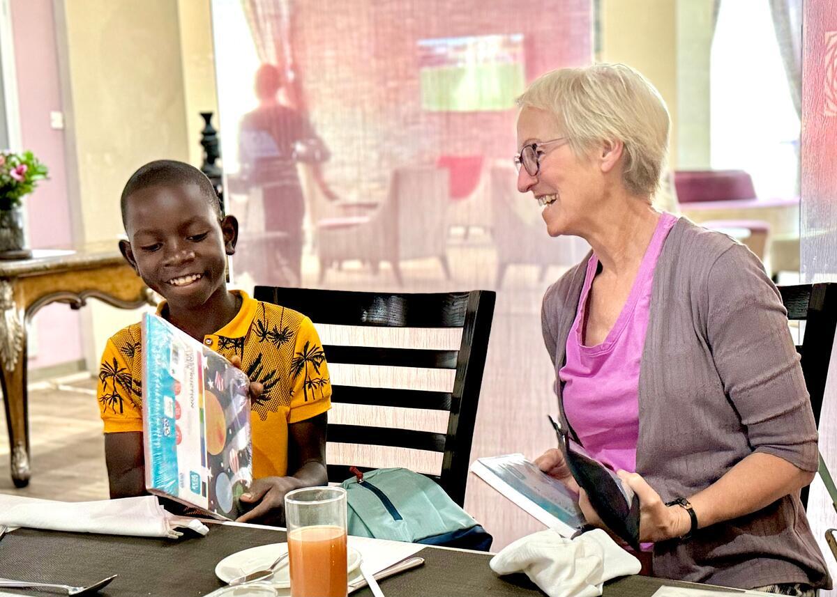 A child sponsor sits at a table with her sponsored child in Malawi