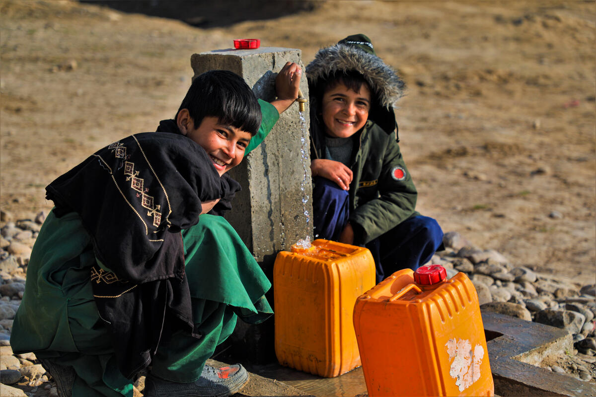 Two boys by water pump