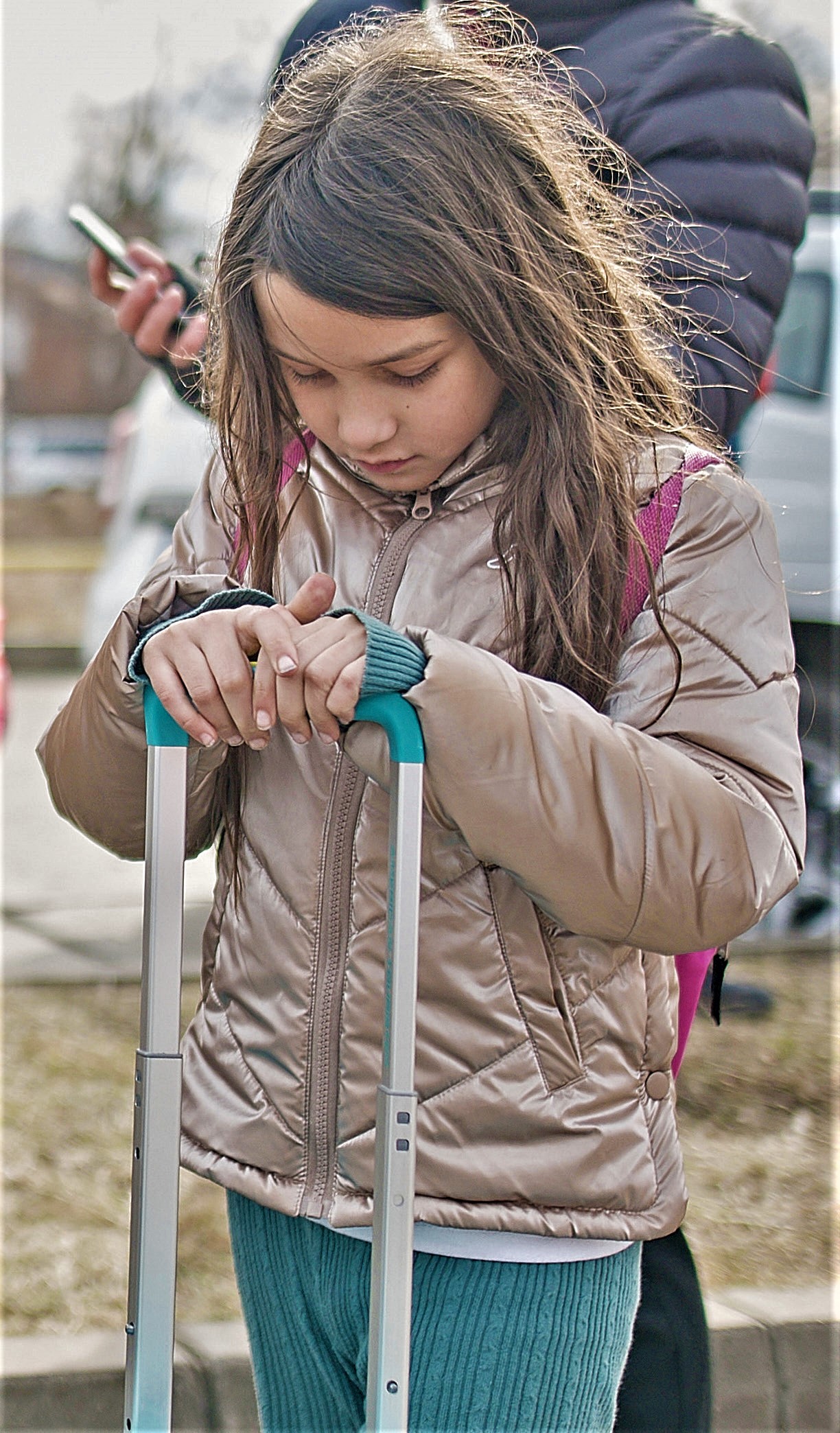 A young girl holds a suitcase
