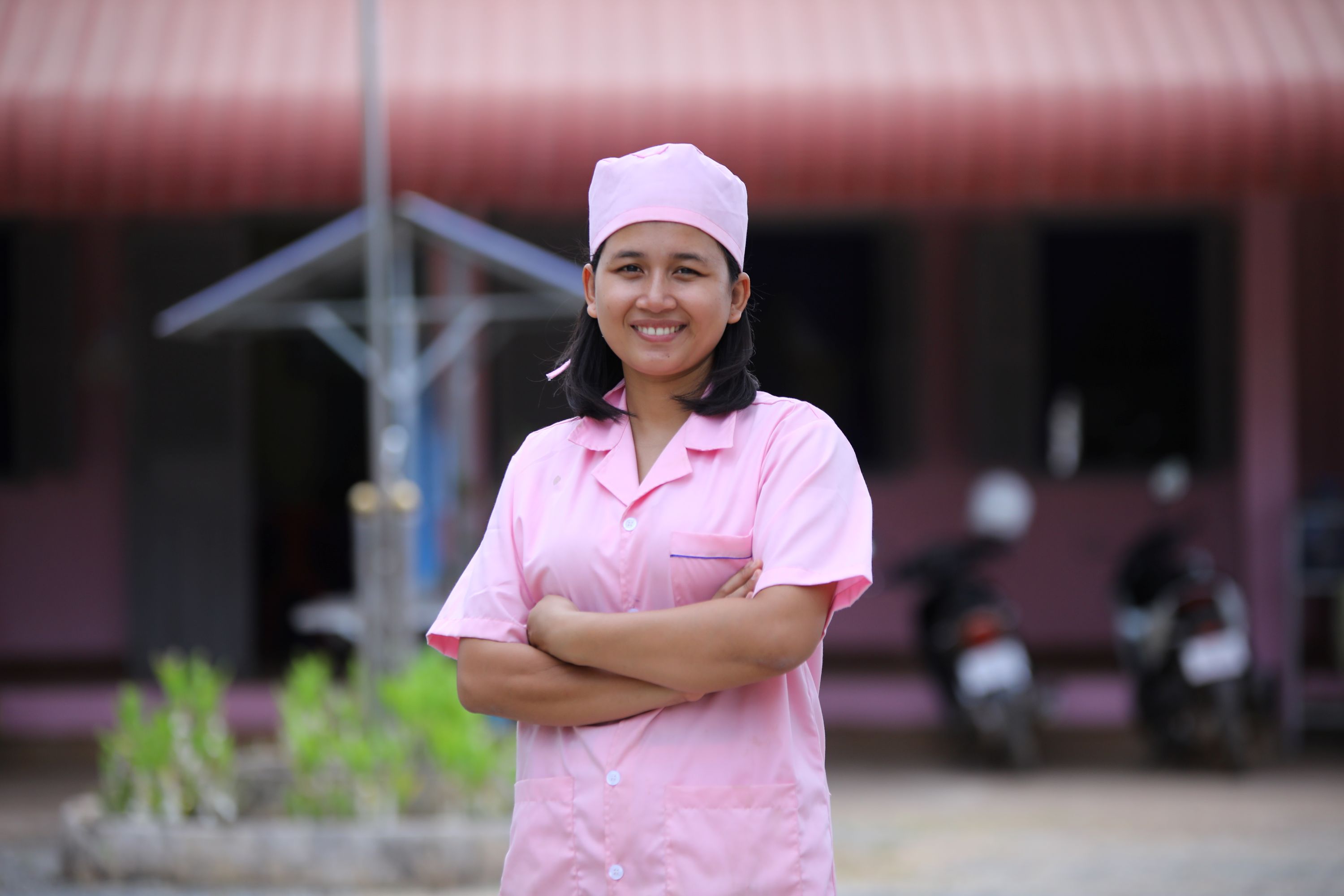 Vithalin in Cambodia poses in her pink nurse's uniform, smiling as she shares about her experience as a former sponsored child