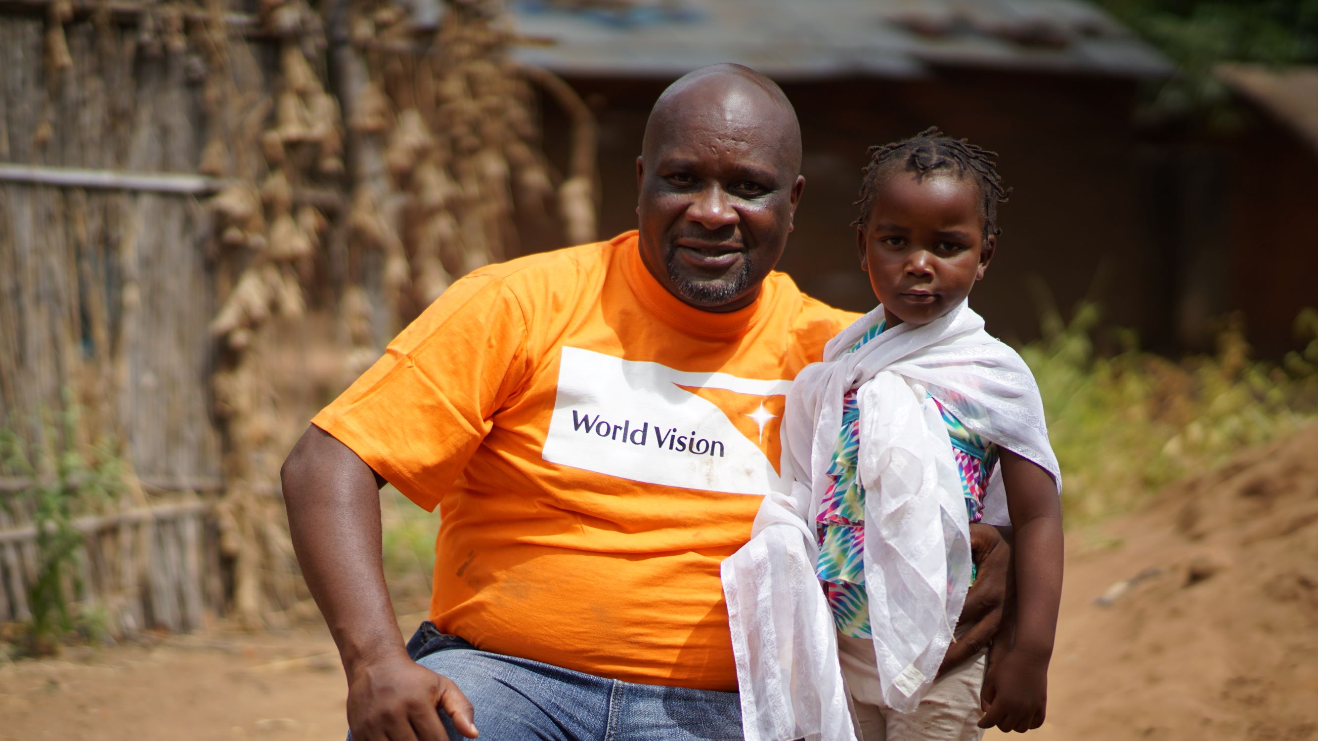 World Vision man with girl in Malawi