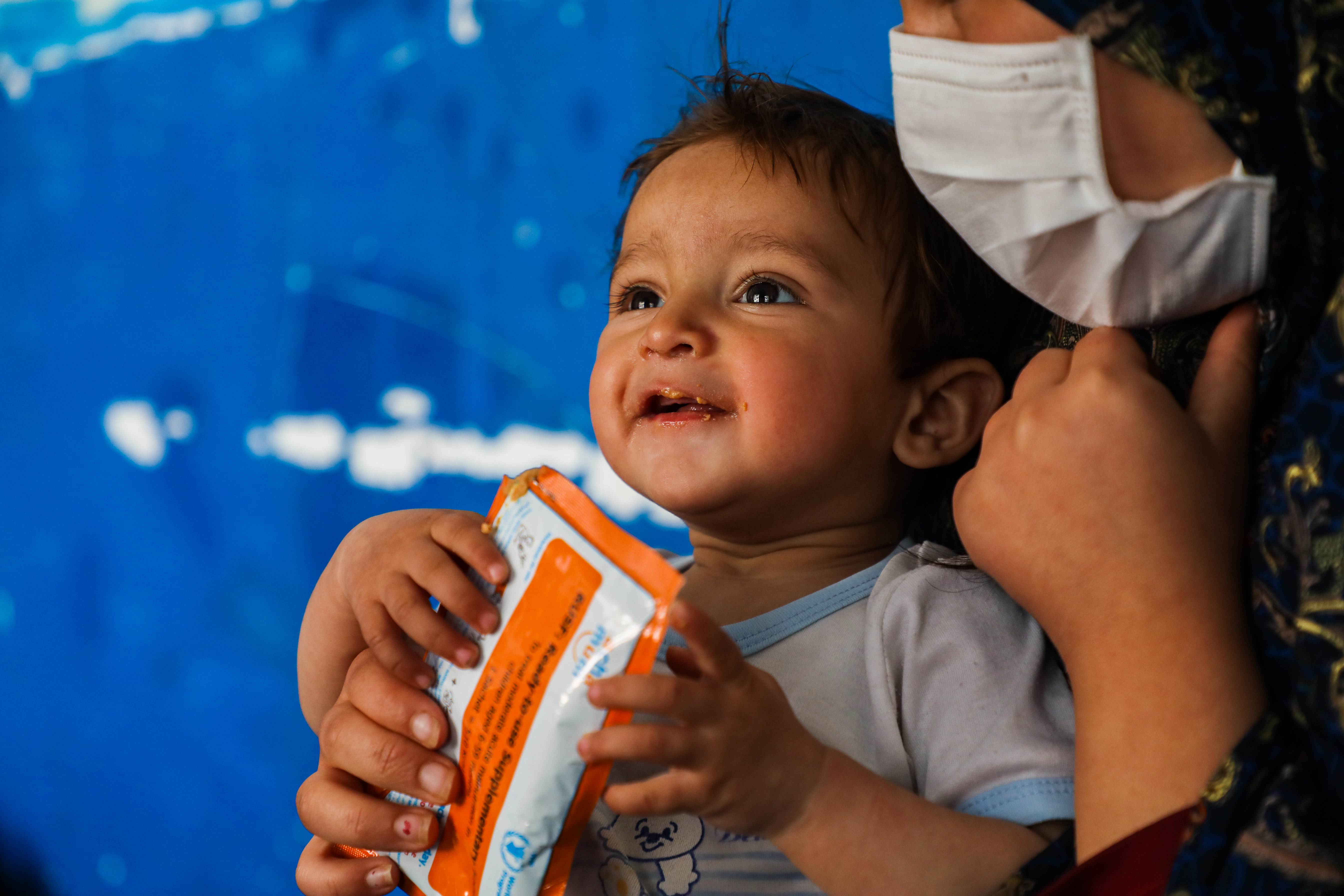 A young boy smiles while being fed