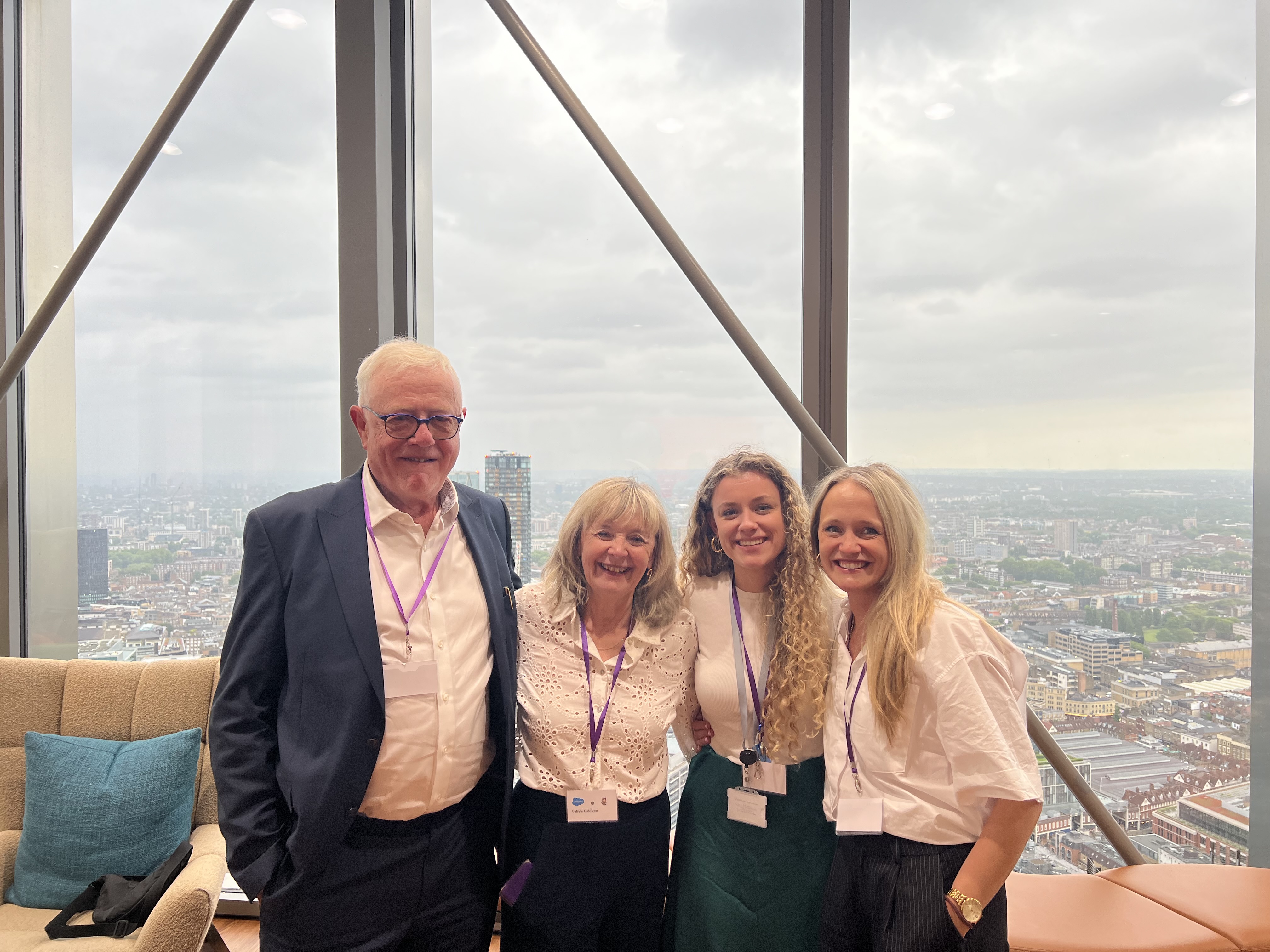 Four staff stand together smiling to camera