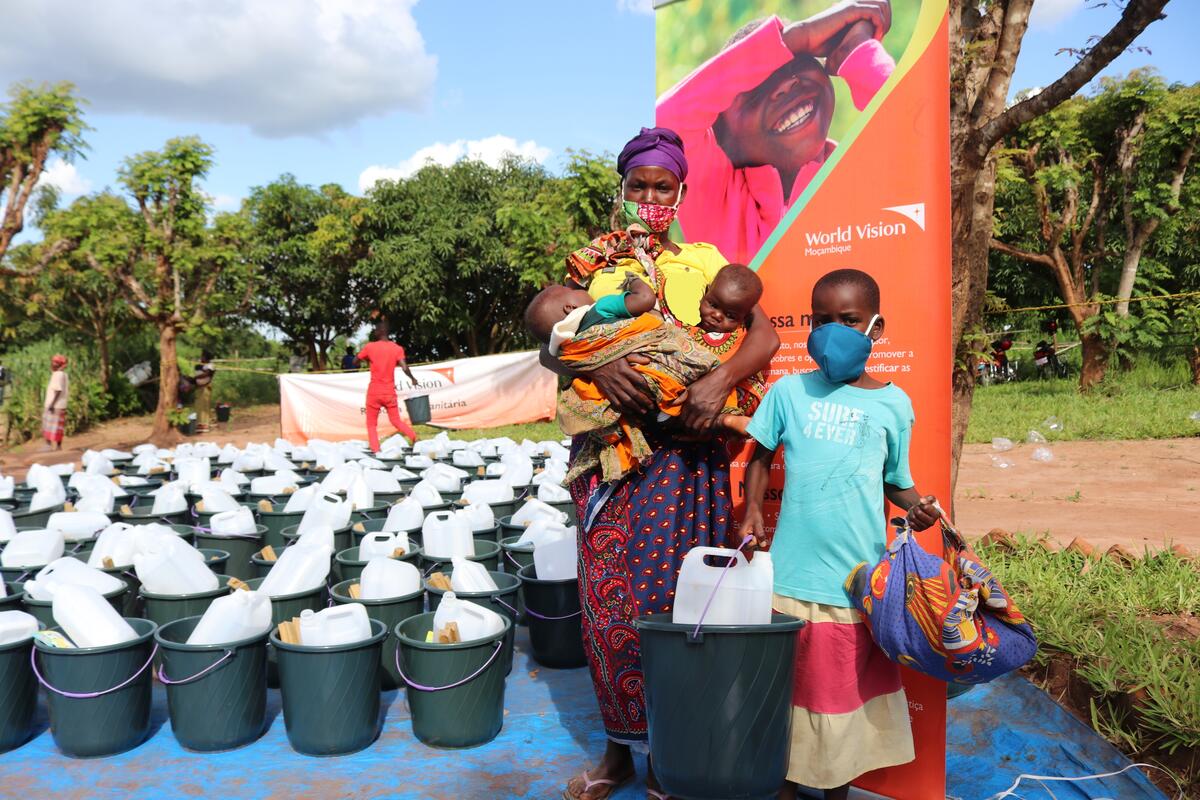 A mother and her children receiving essential survival non-food items after Cyclone Chalanee